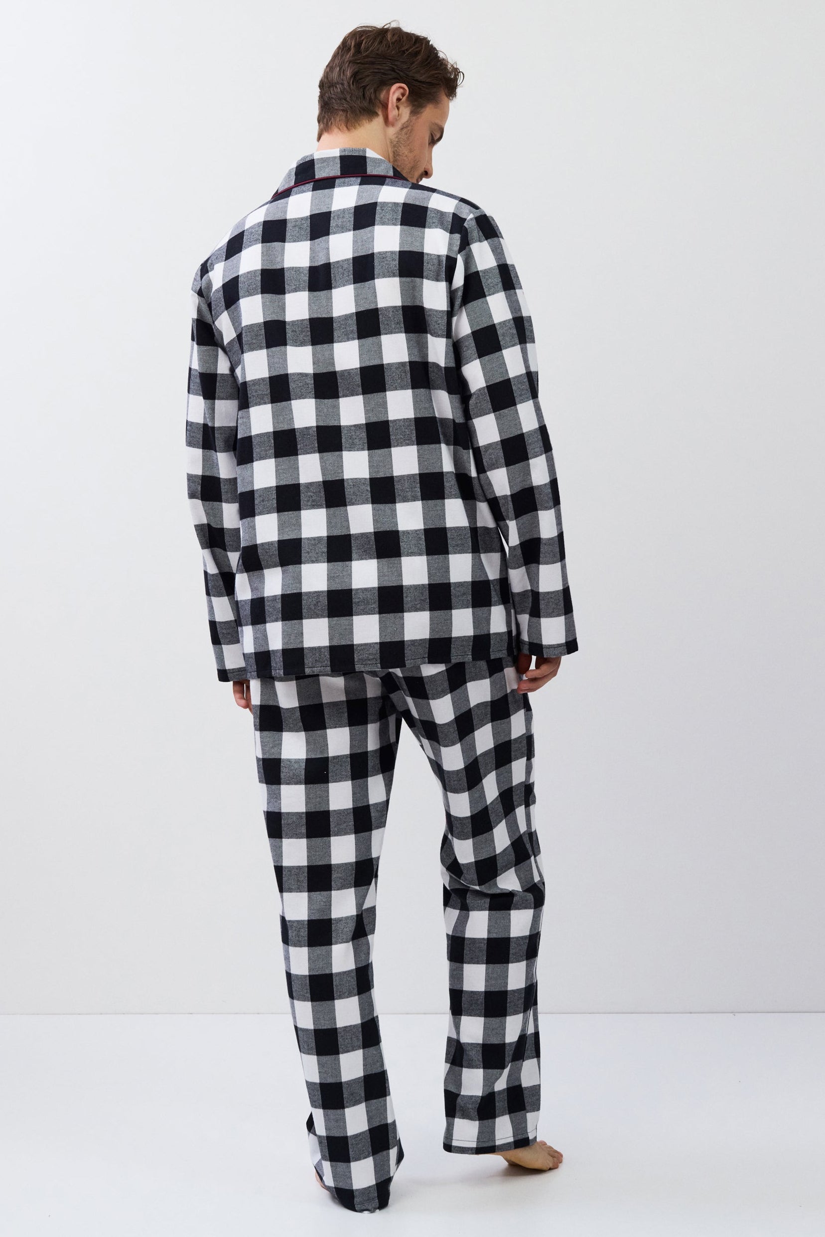 Man wearing a black and white checkered outfit on a white background