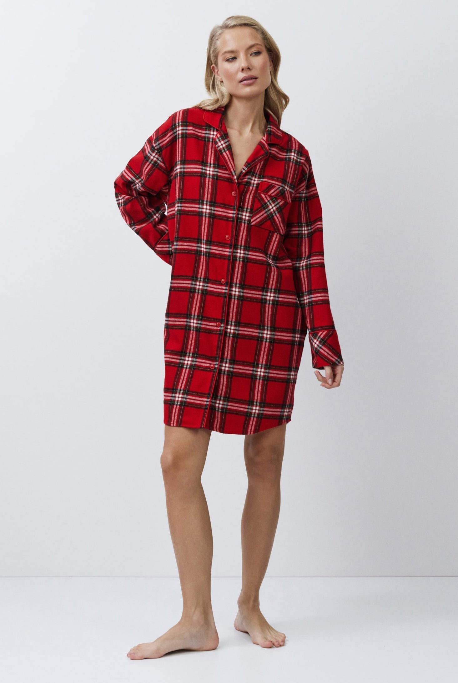 Person wearing a red plaid shirt dress on a white background