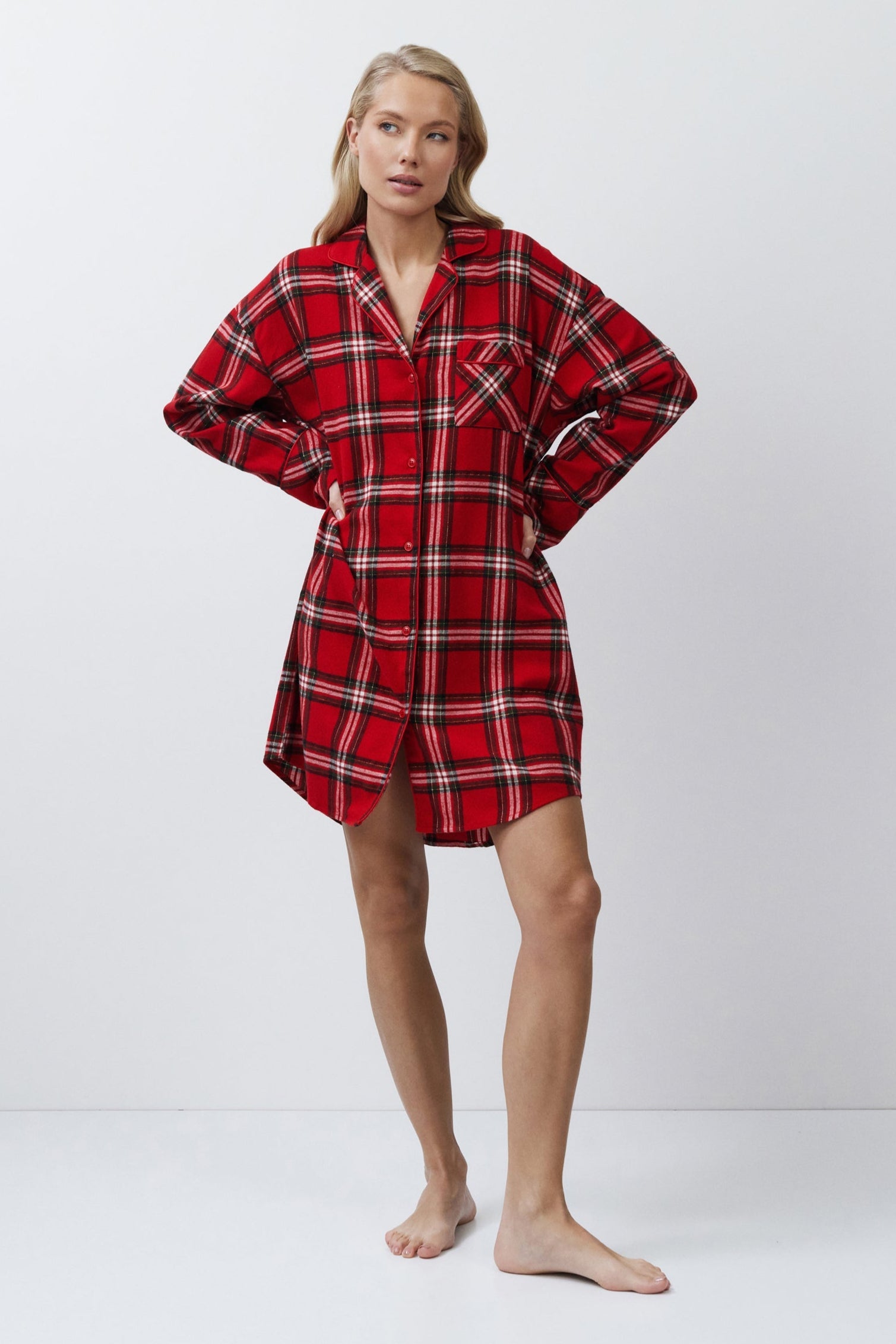 Person wearing a red plaid shirt dress on a white background