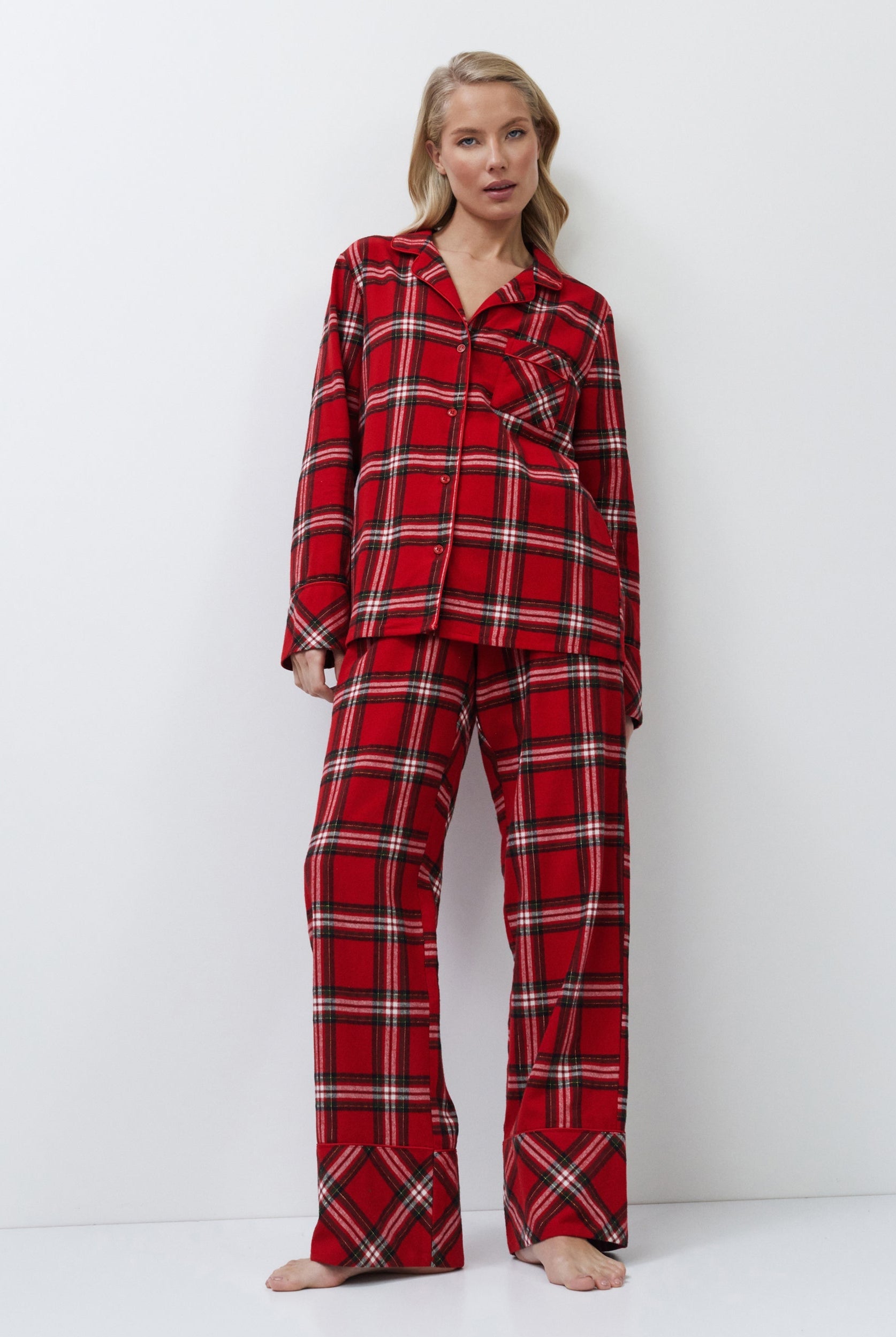 Woman wearing red plaid pajamas on a white background