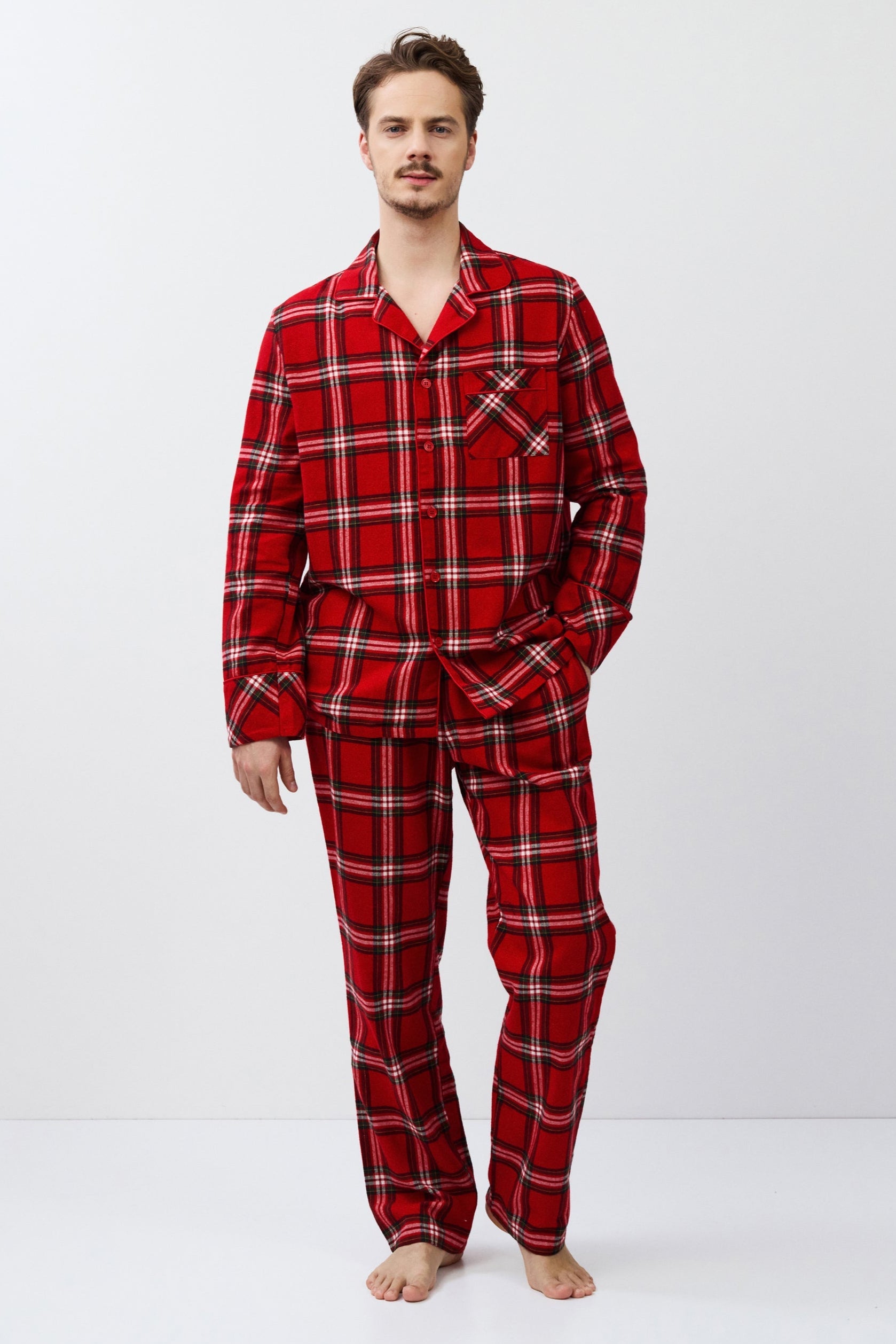 Man wearing red plaid pajamas on a white background