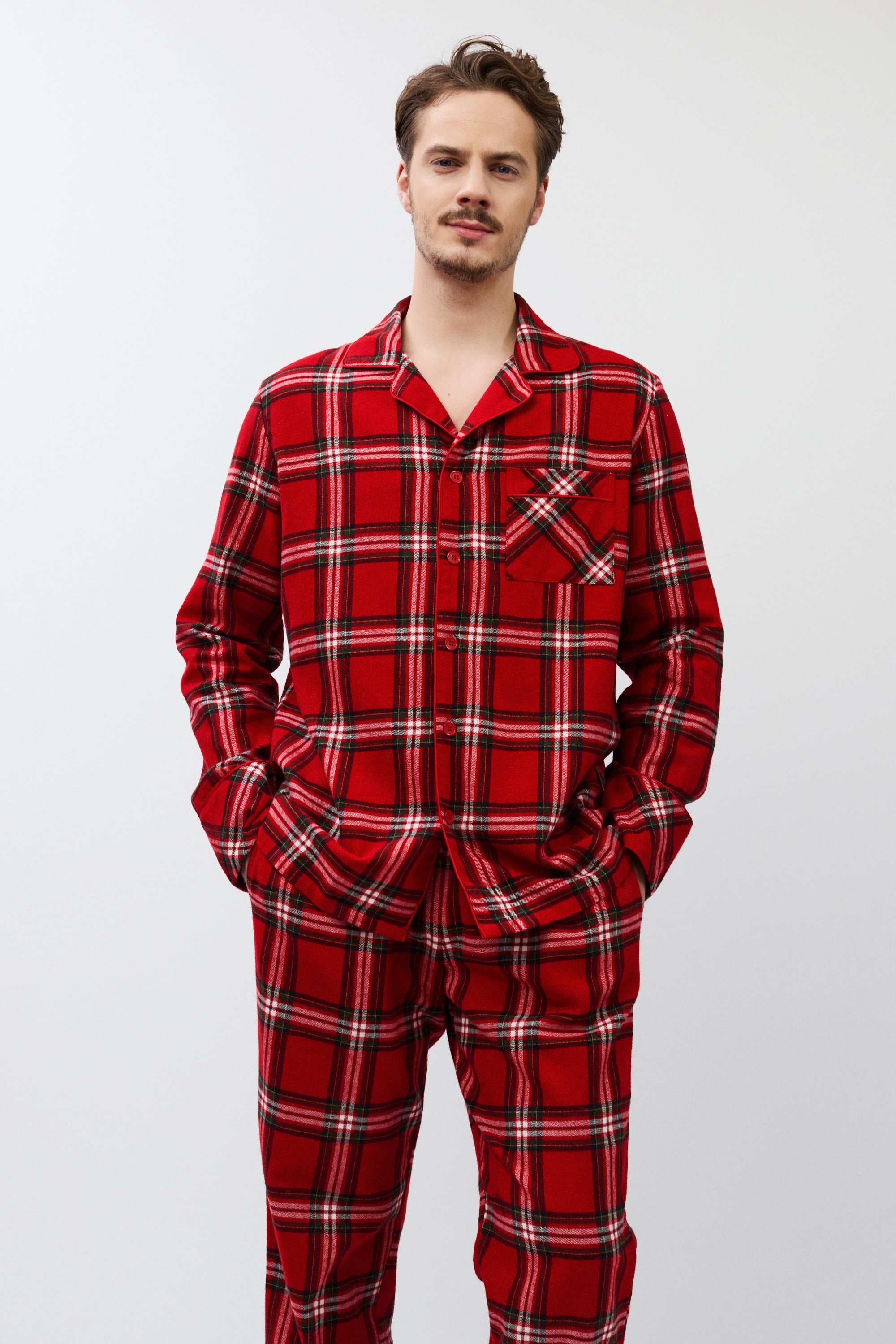 Man wearing red plaid pajamas on a white background