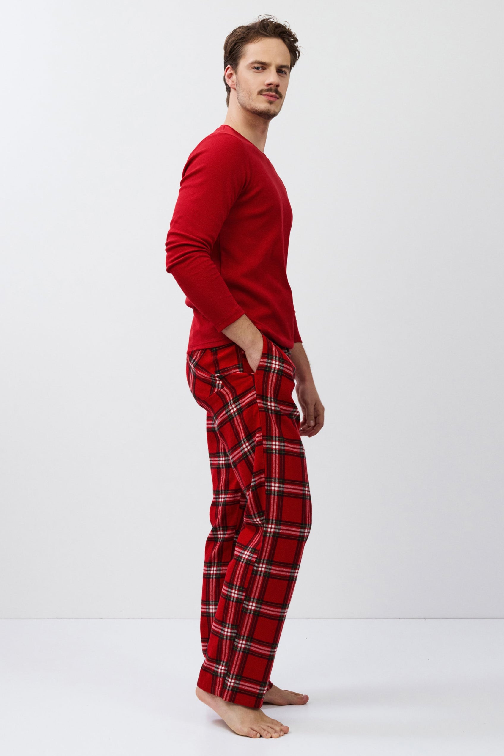 Man wearing red plaid pajamas on a white background