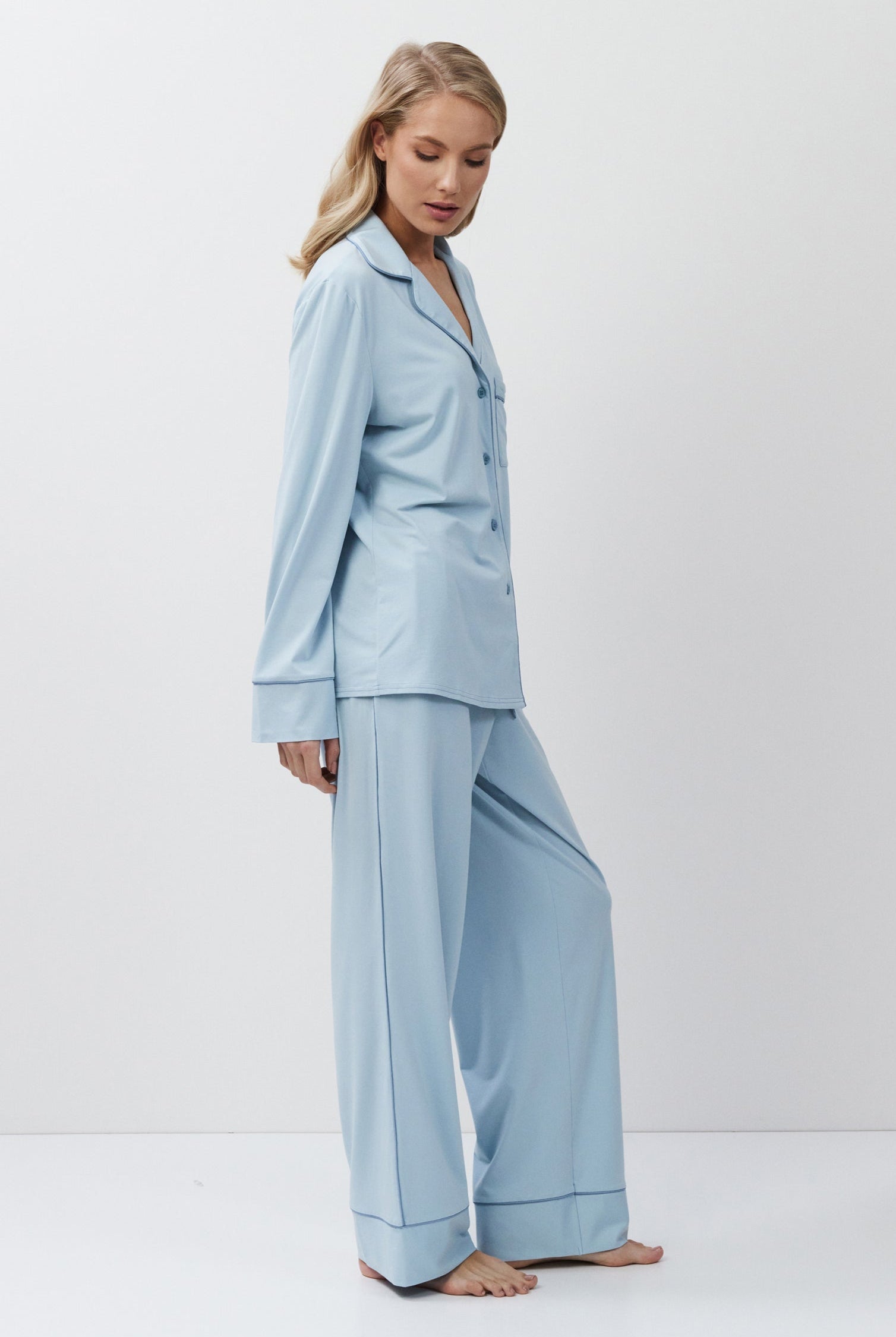 Woman wearing a light blue pajama set against a white background