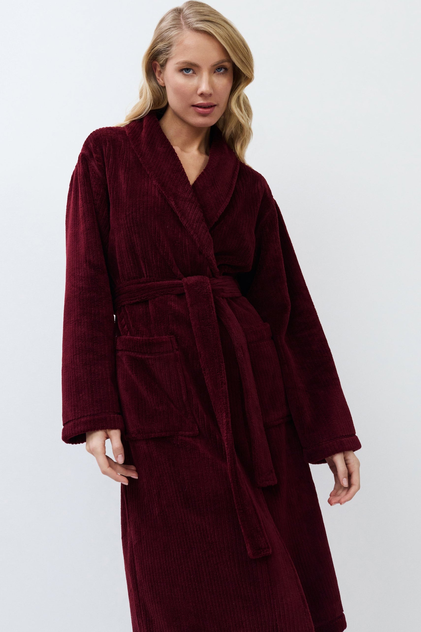 Woman wearing a burgundy robe against a white background
