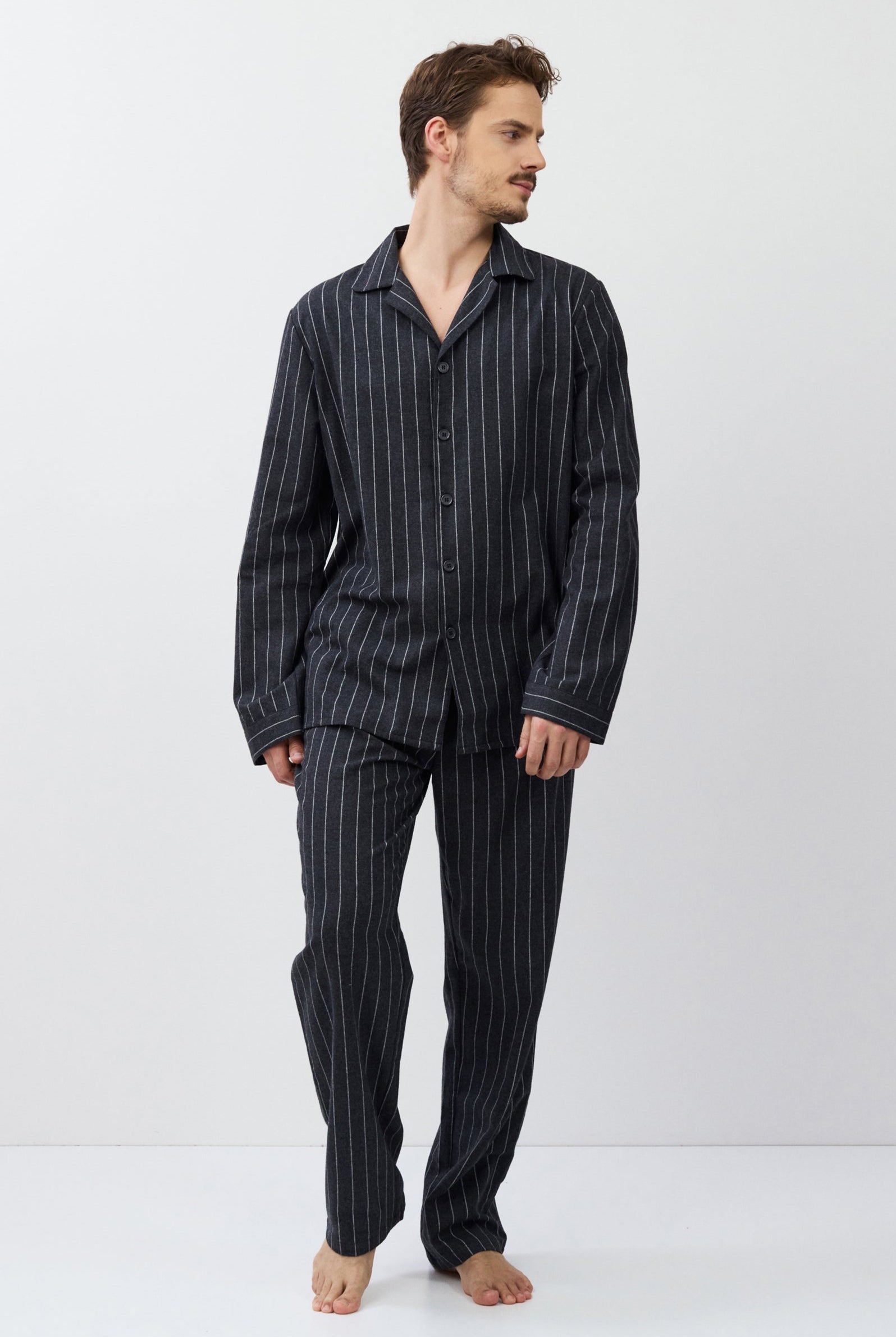 Man wearing a striped pajama set on a white background