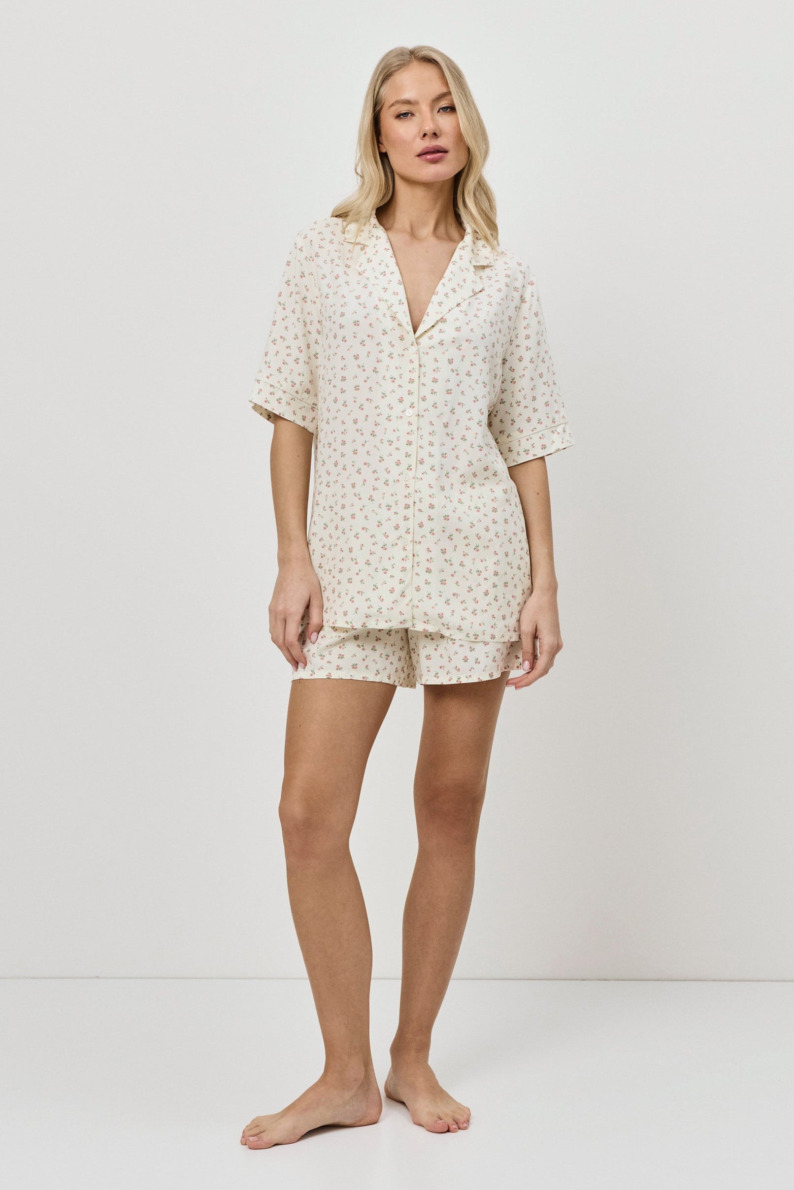 Woman wearing a butter yellow pajama set on a plain background