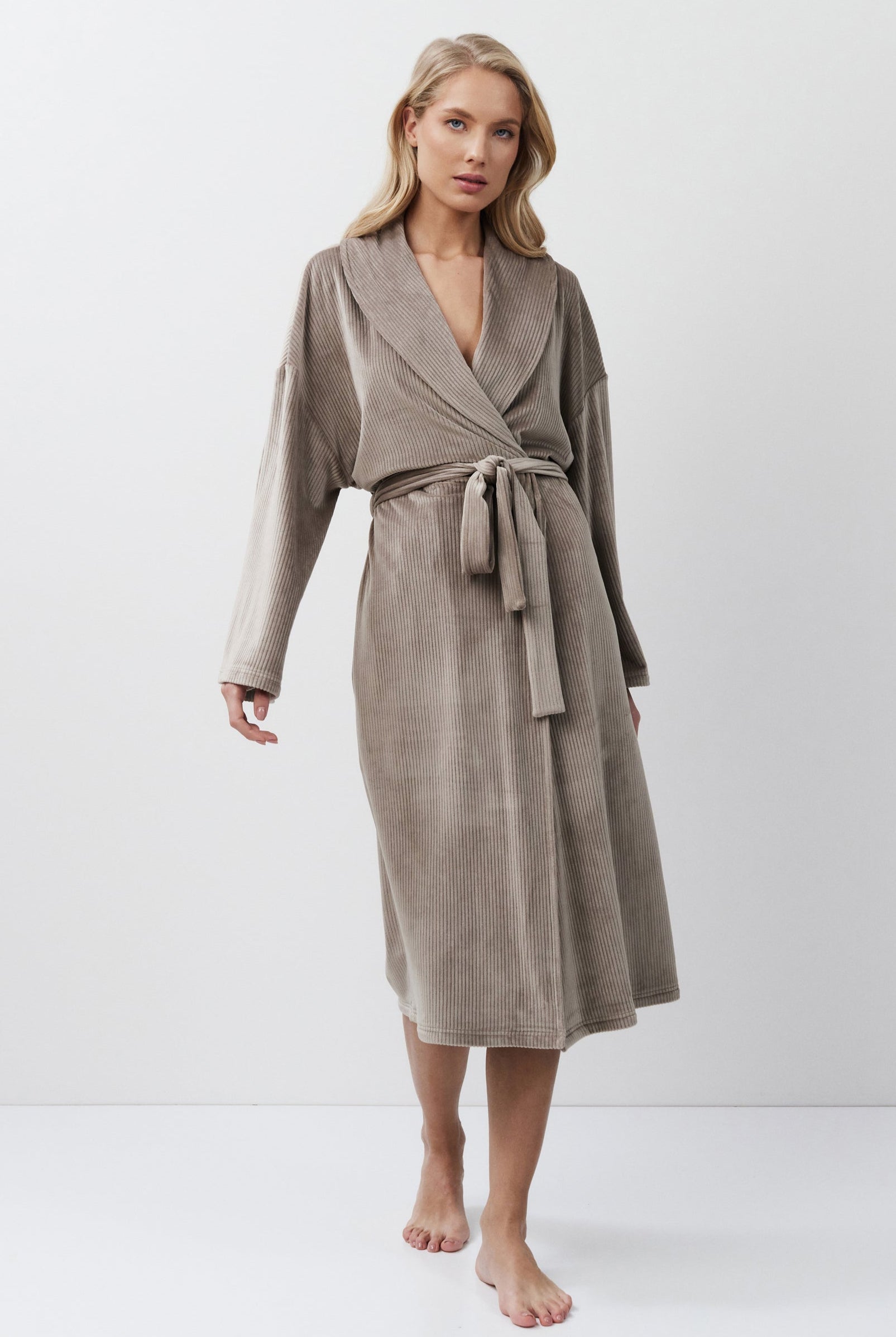 Woman wearing a capucine robe against a white background