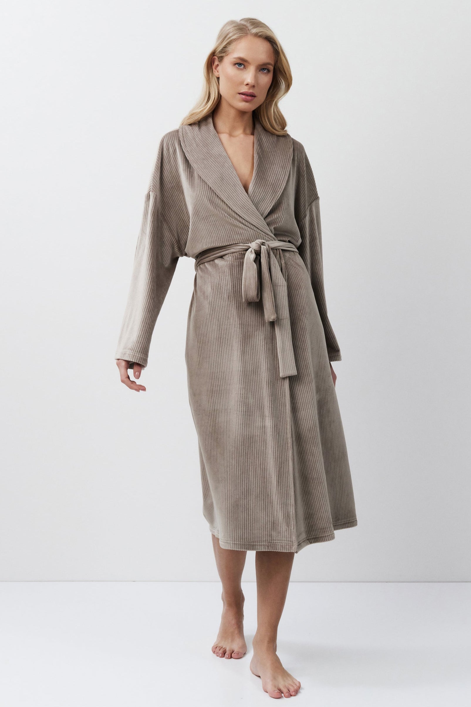 Woman wearing a capucine robe against a white background