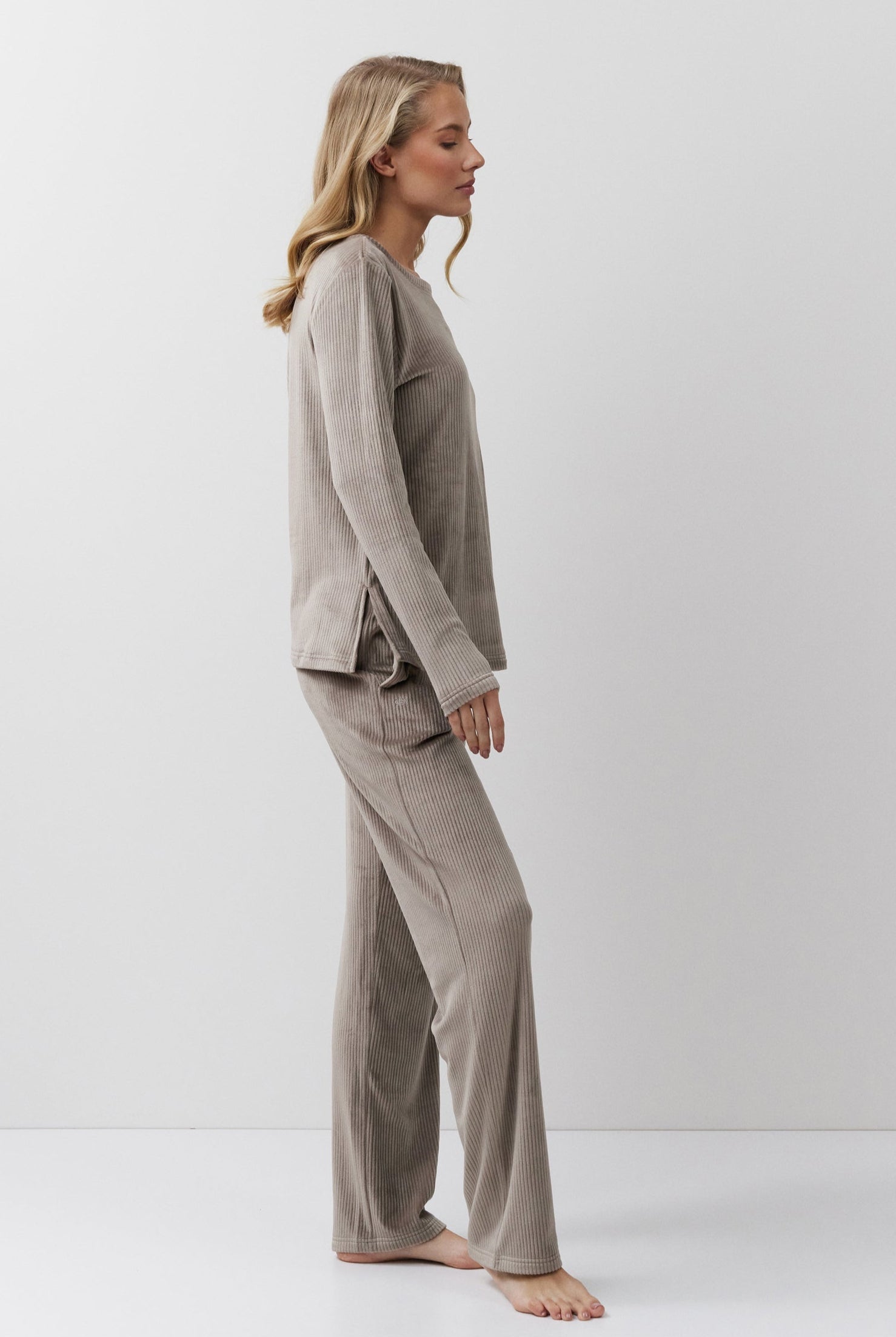 Woman wearing a capucine pajama set against a white background