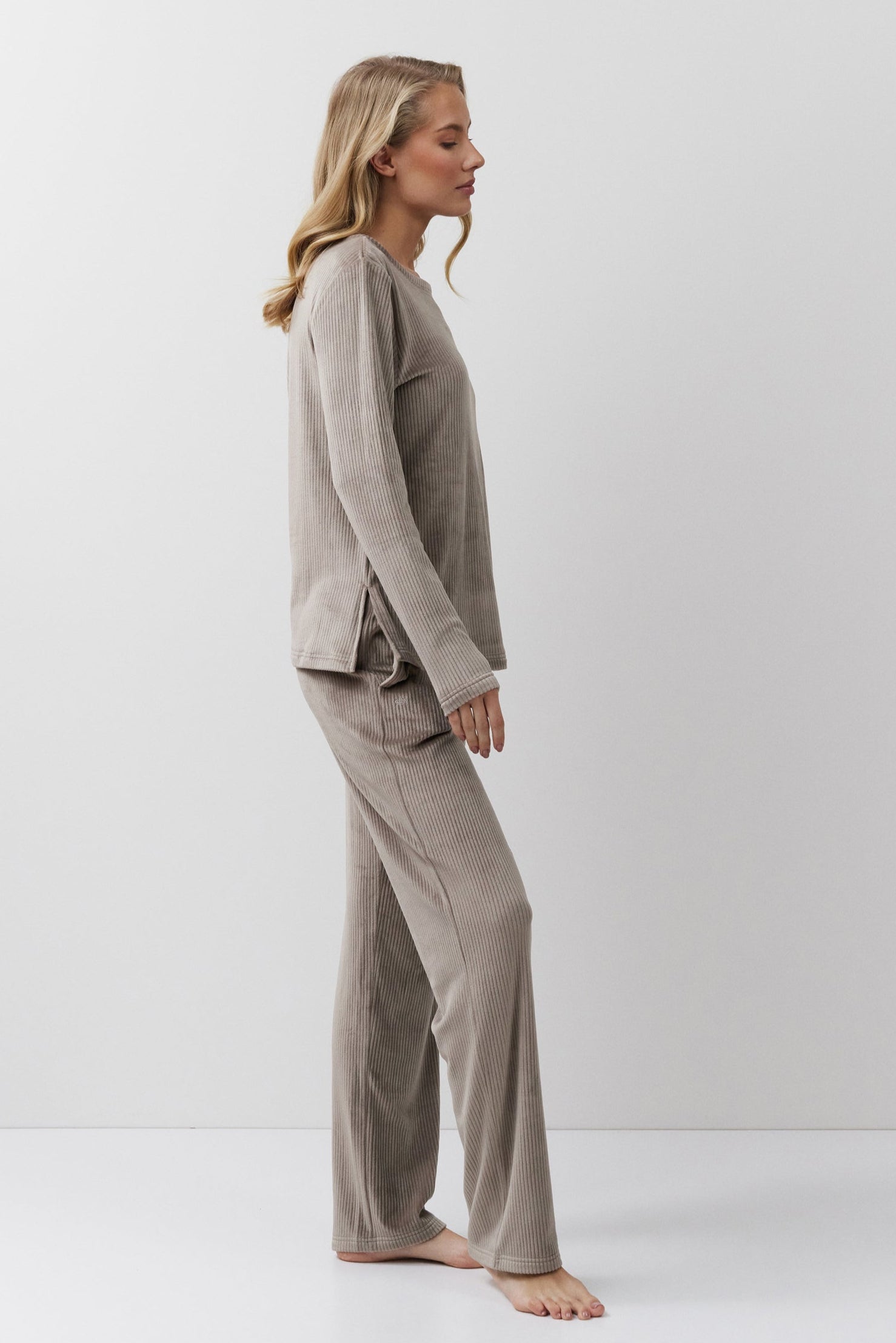 Woman wearing a capucine pajama set against a white background