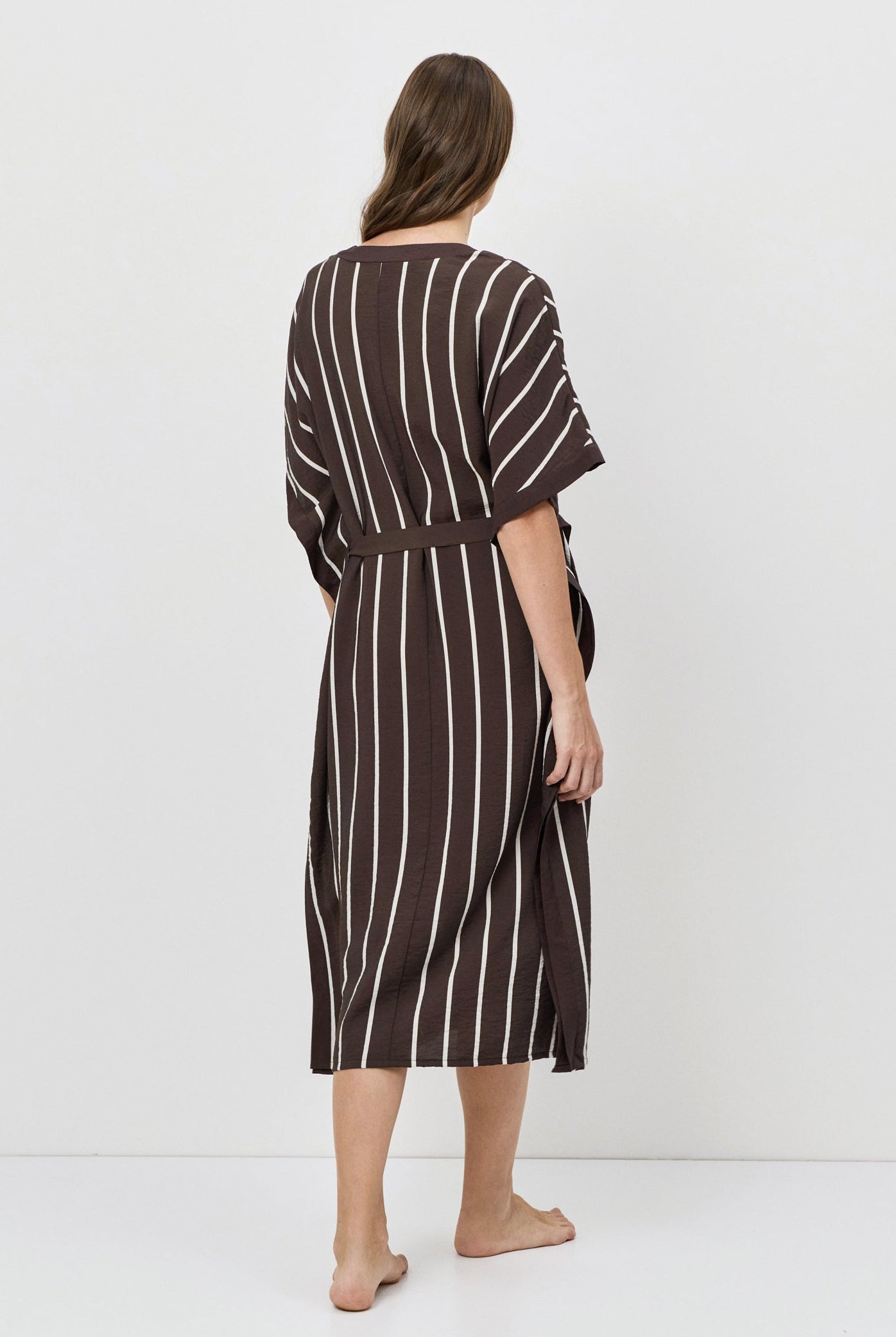 Woman wearing a striped dress on a white background