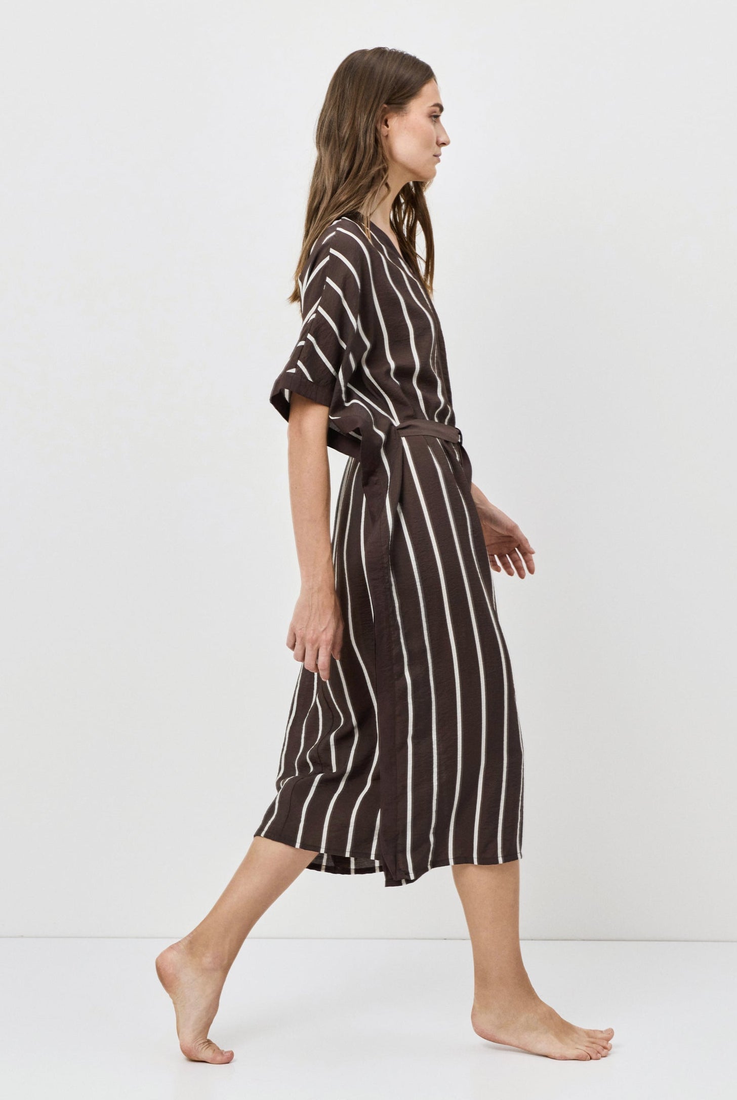 Woman wearing a striped dress on a white background