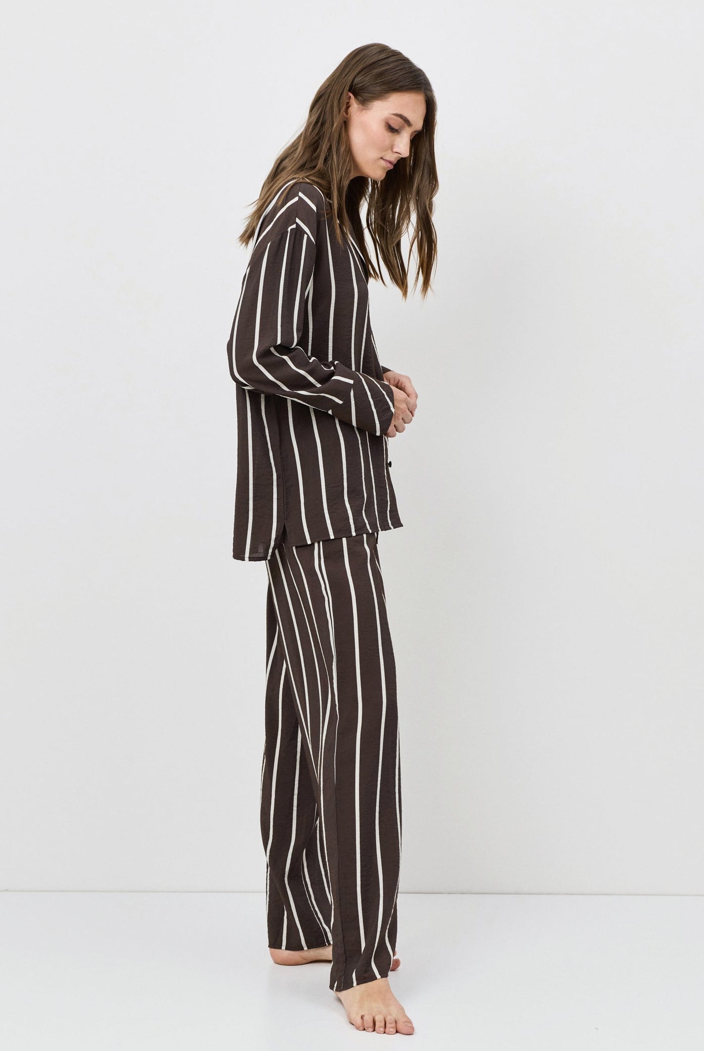 Woman wearing a black and white striped resort wear set against a white background