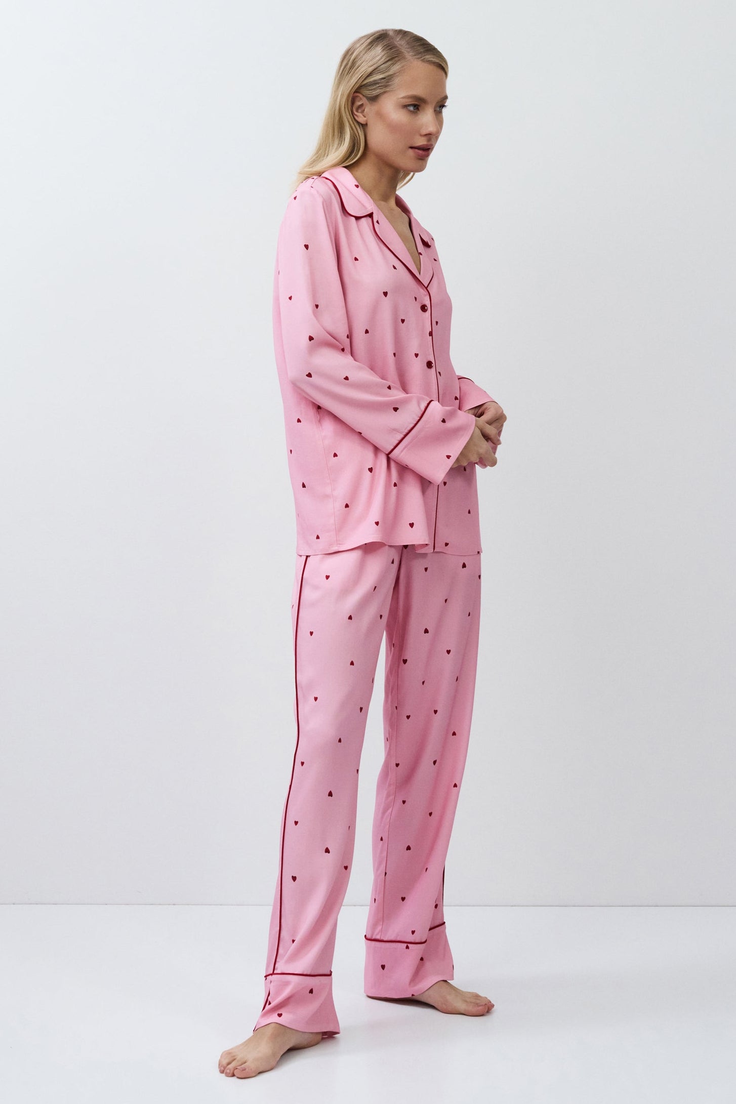 Woman wearing a pink pajama set with a white background