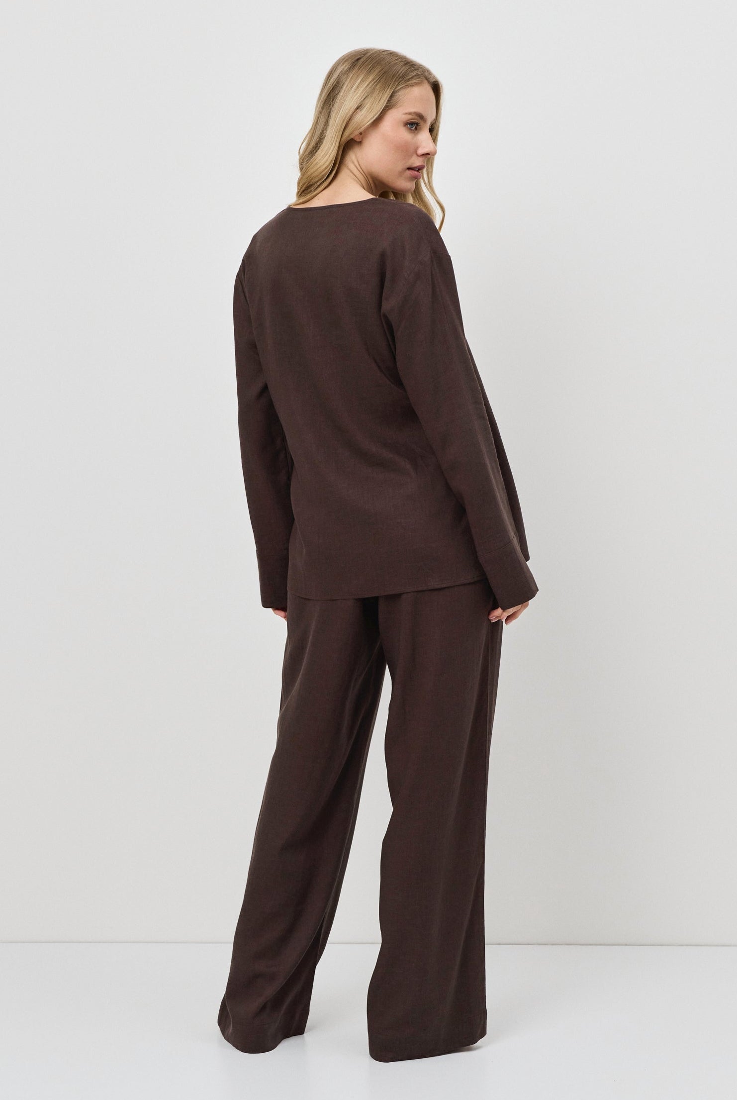 Woman wearing a brown resort wear set against a white background