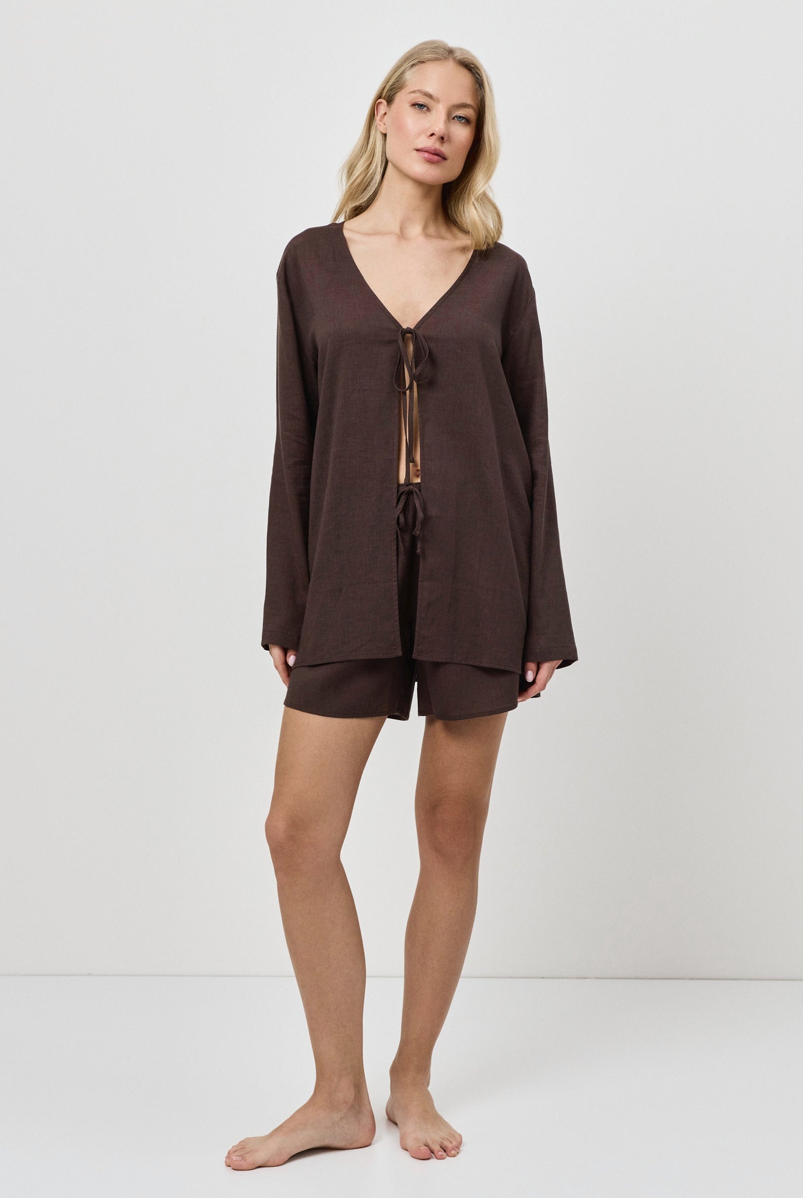 Woman wearing a brown resort wear set with a plain white background