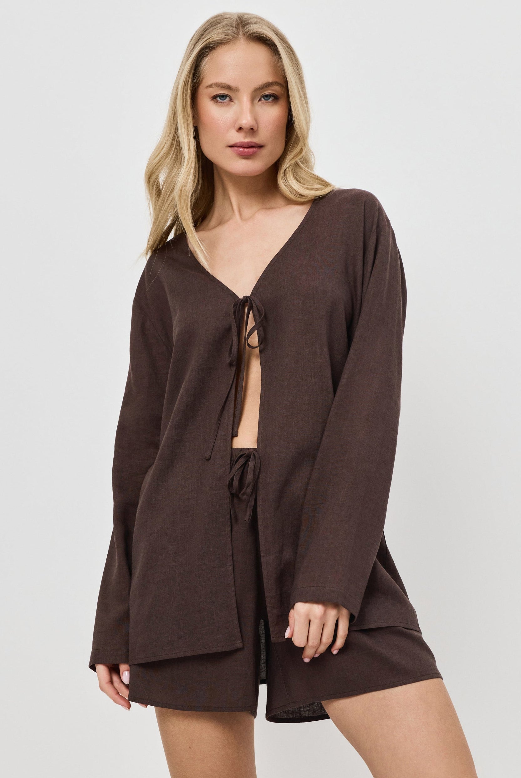 Woman wearing a brown resort wear set on a white background