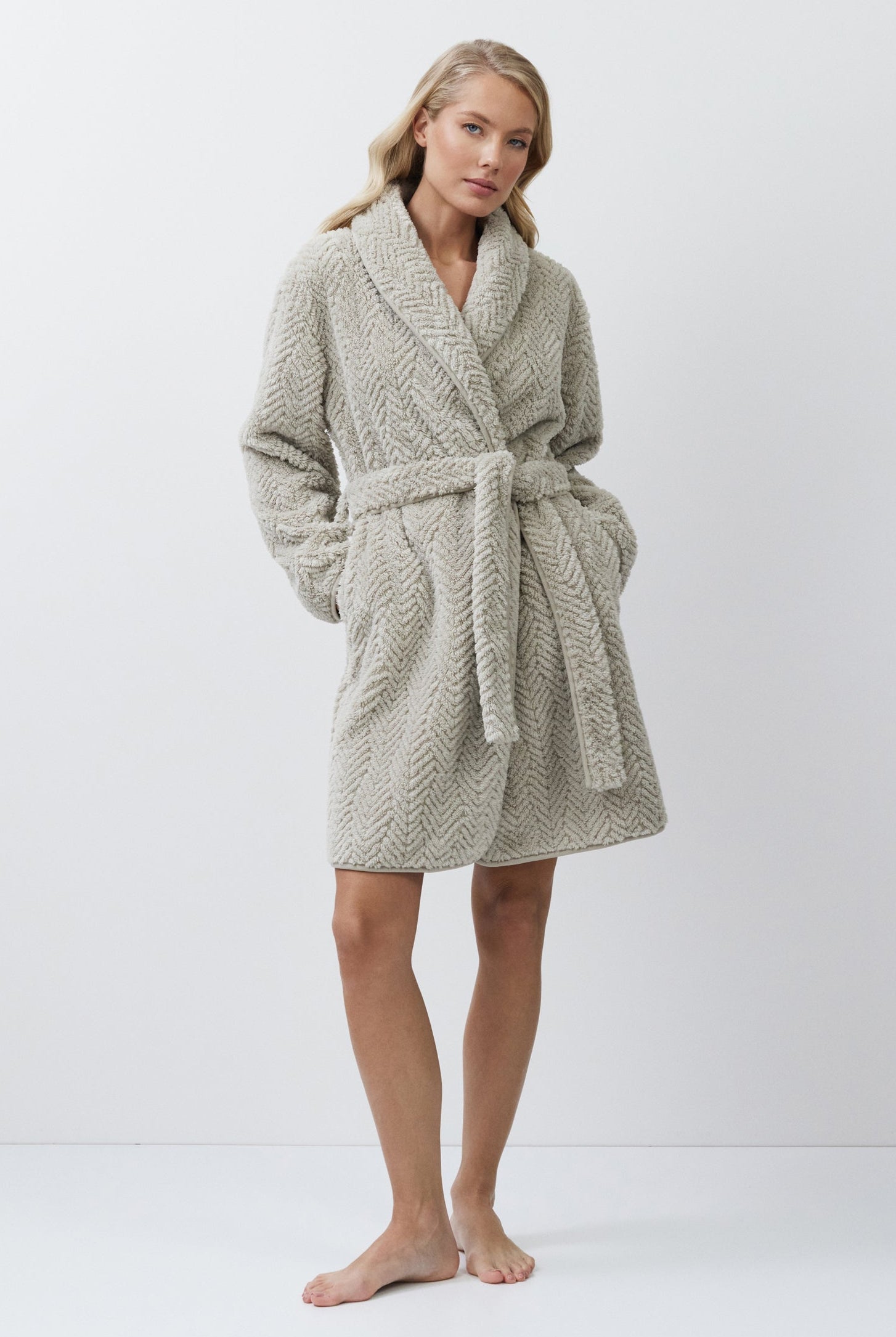 Woman wearing a beige bathrobe on a white background