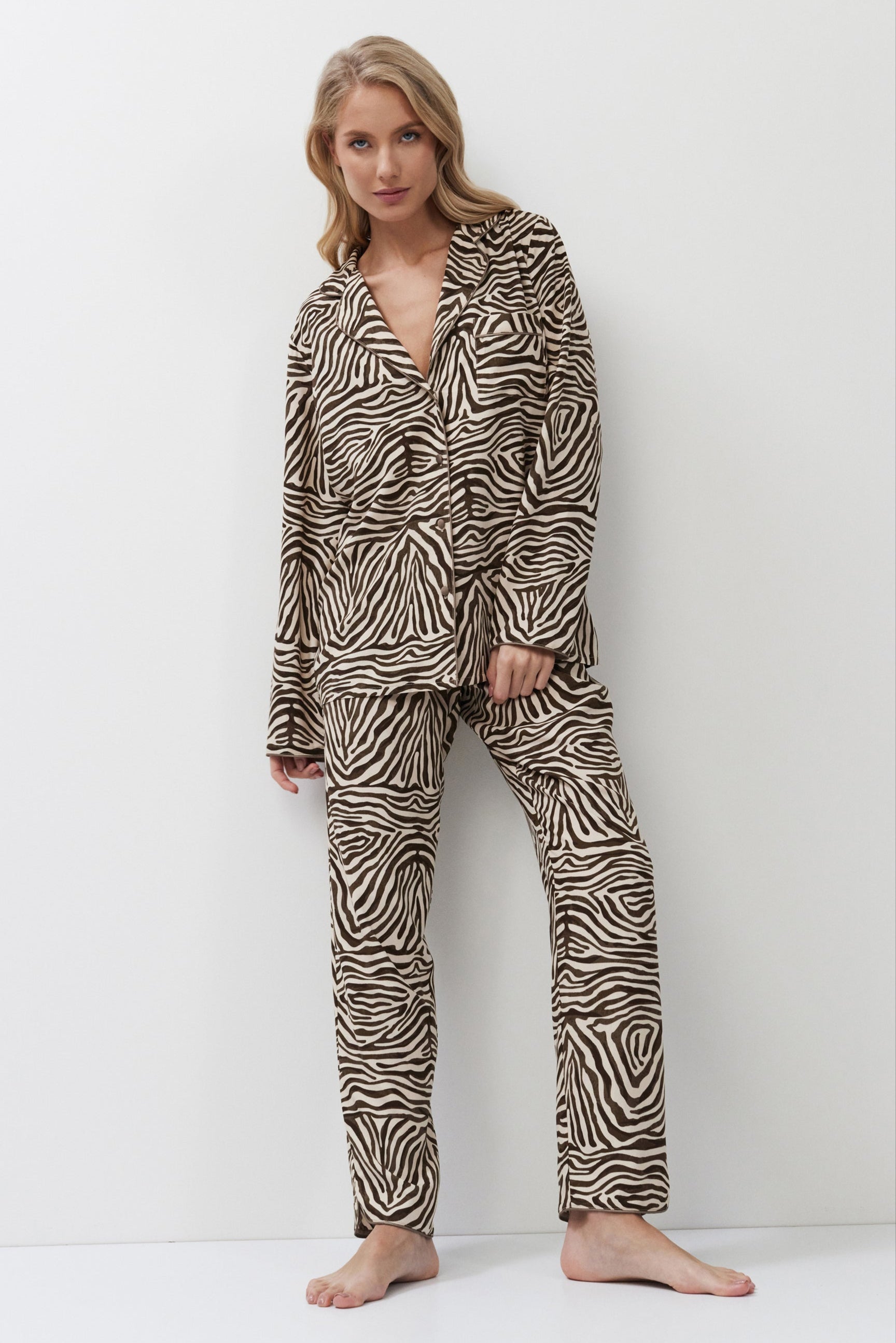Woman wearing zebra print pajamas against a white background