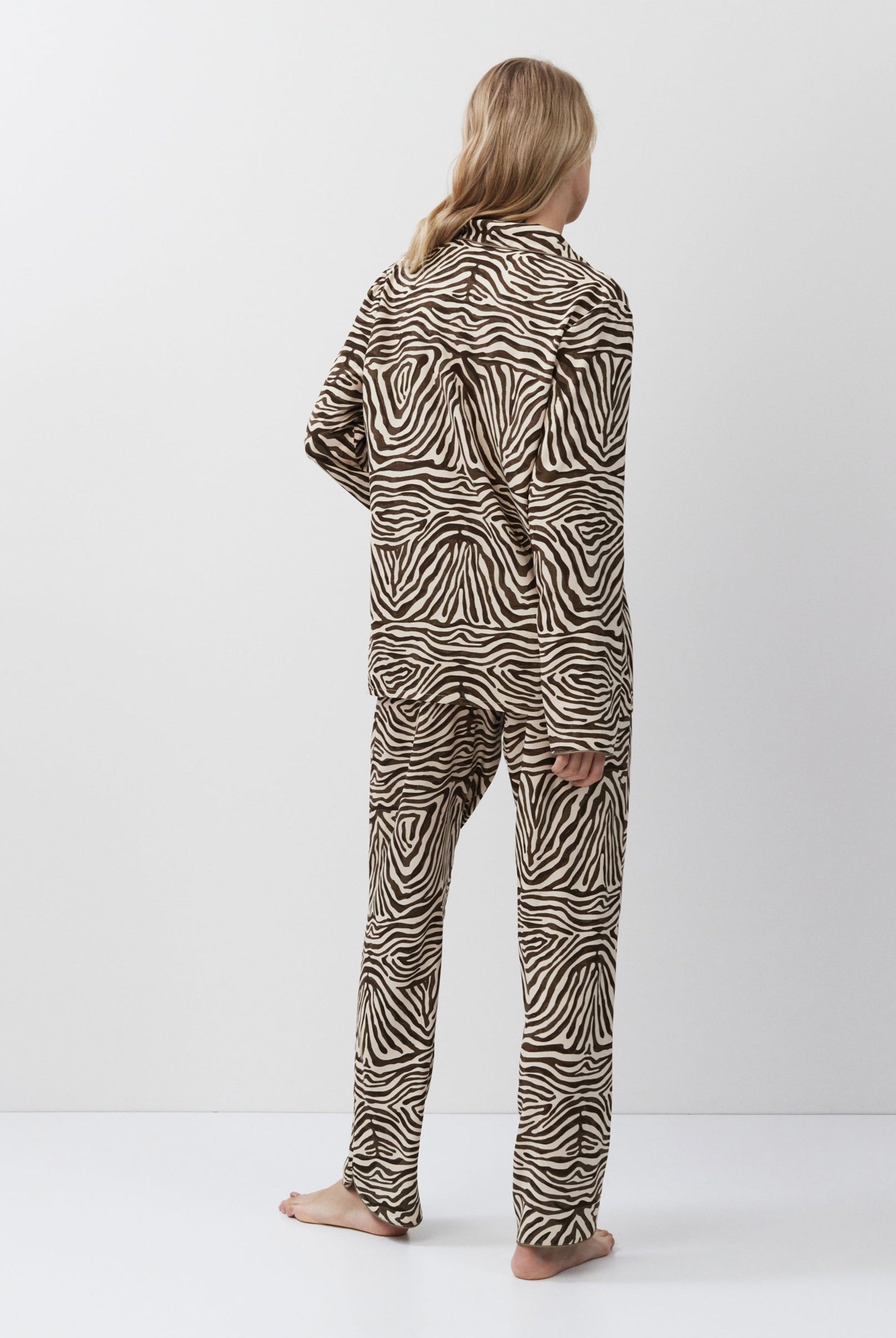 Person wearing zebra print pajamas on a white background