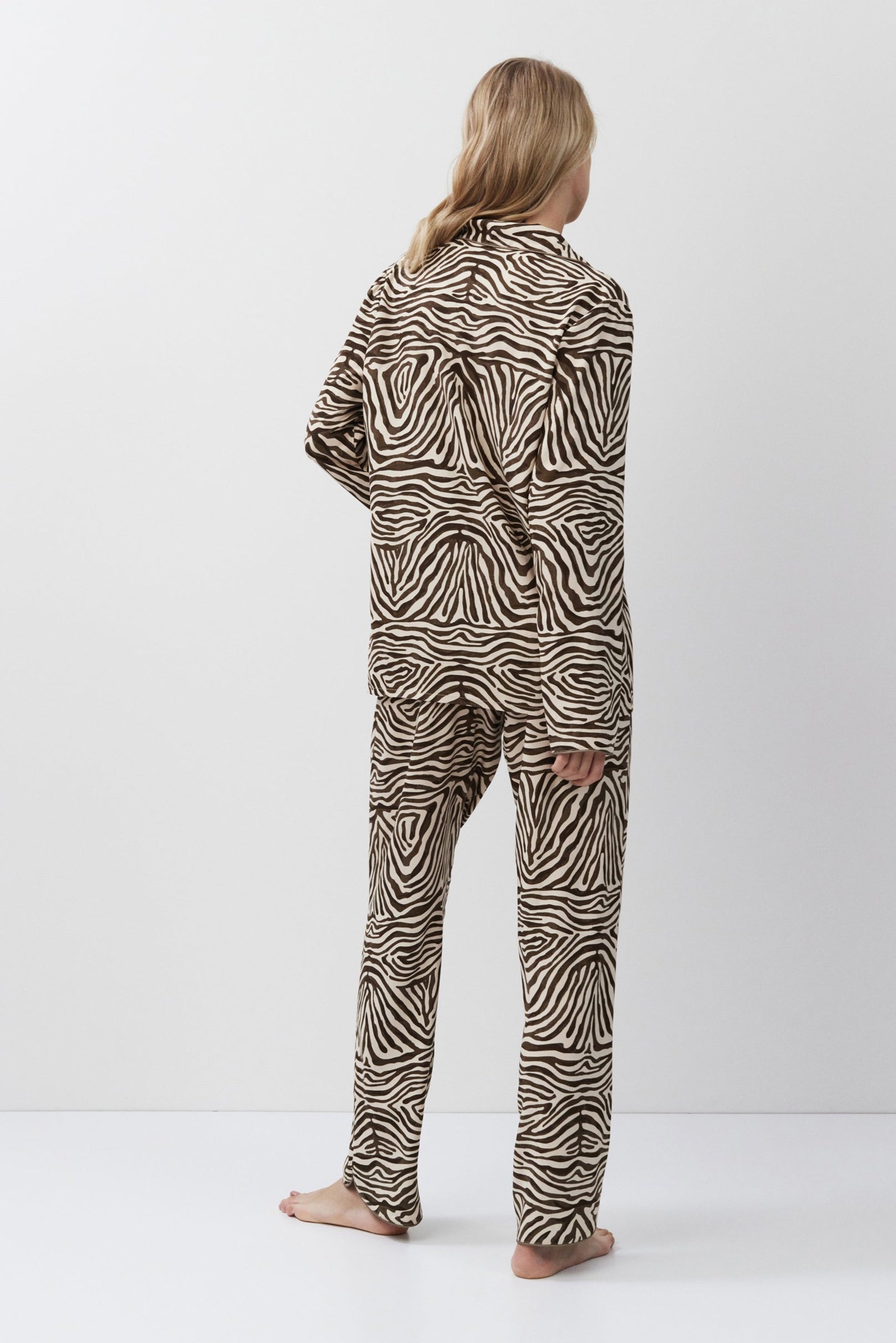 Person wearing zebra print pajamas on a white background