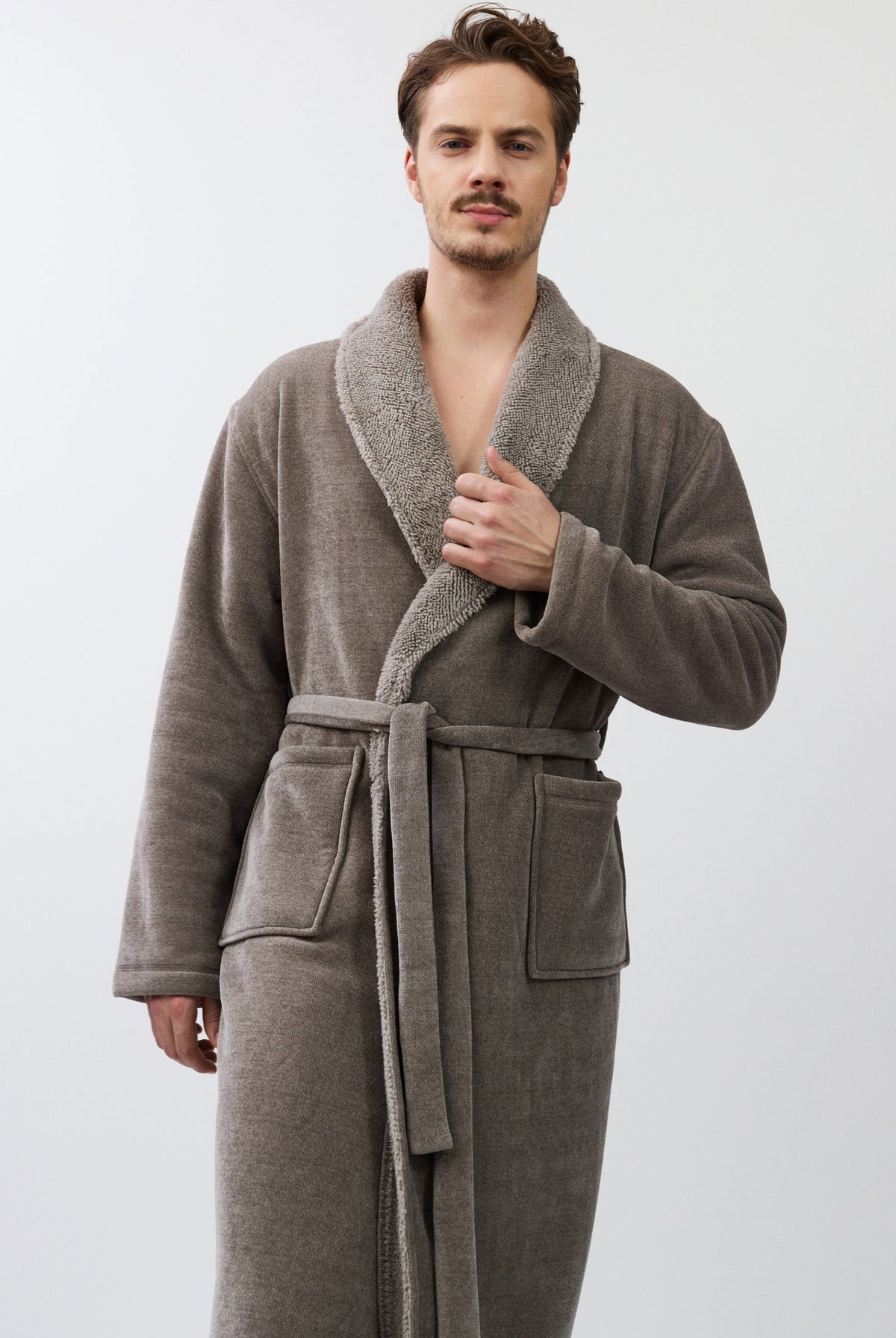 Man wearing a brown robe against a white background