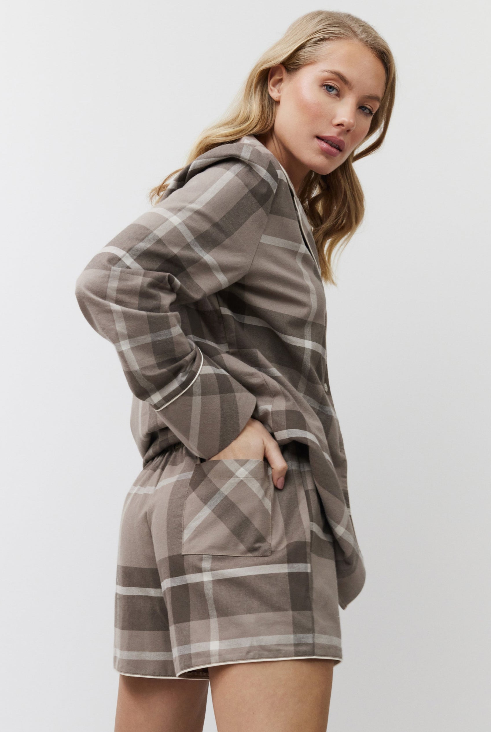 Woman wearing a plaid pajama set on a white background