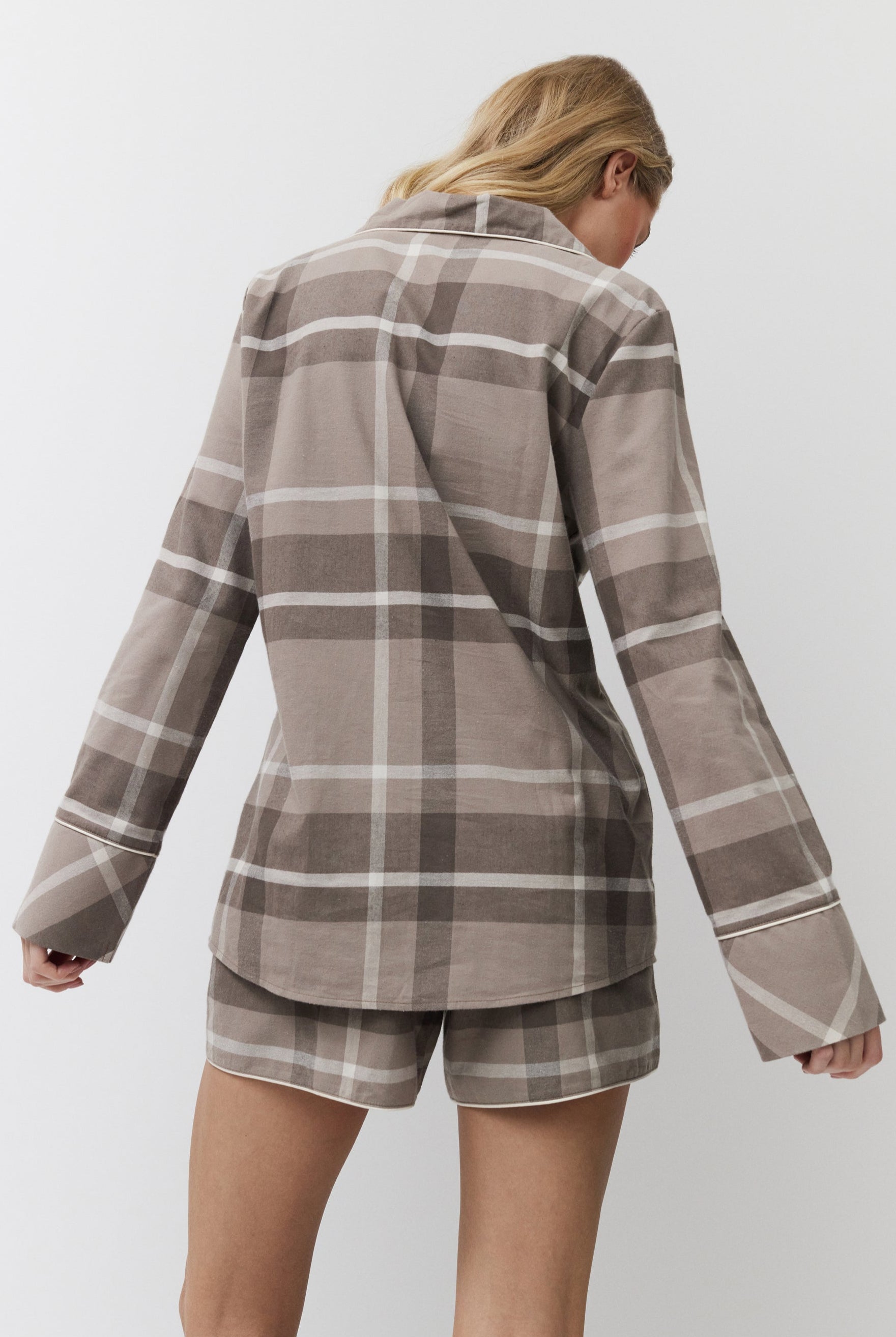 Person wearing a plaid shirt and shorts set on a white background