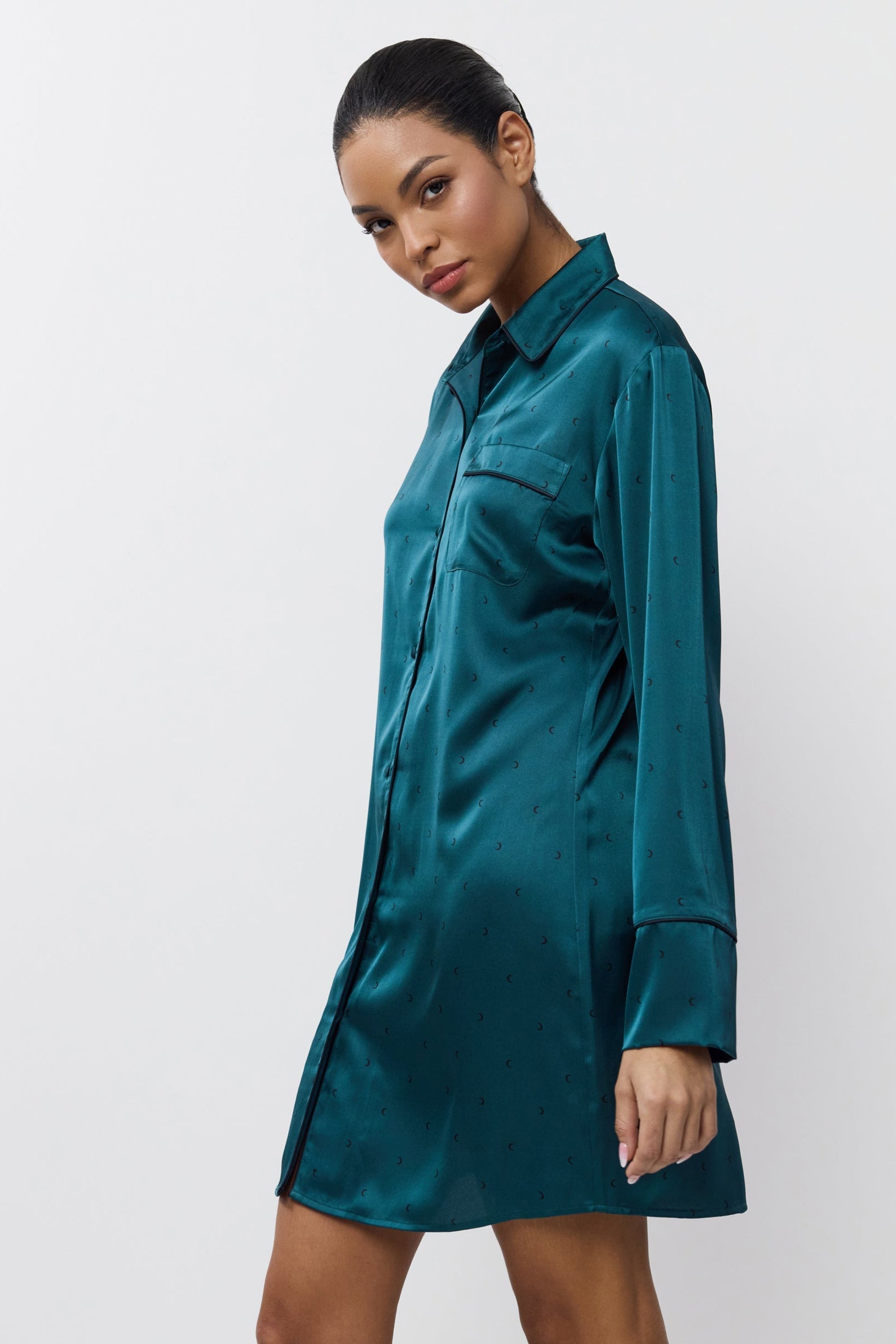 Woman wearing a satin shirt nightdress against a white background
