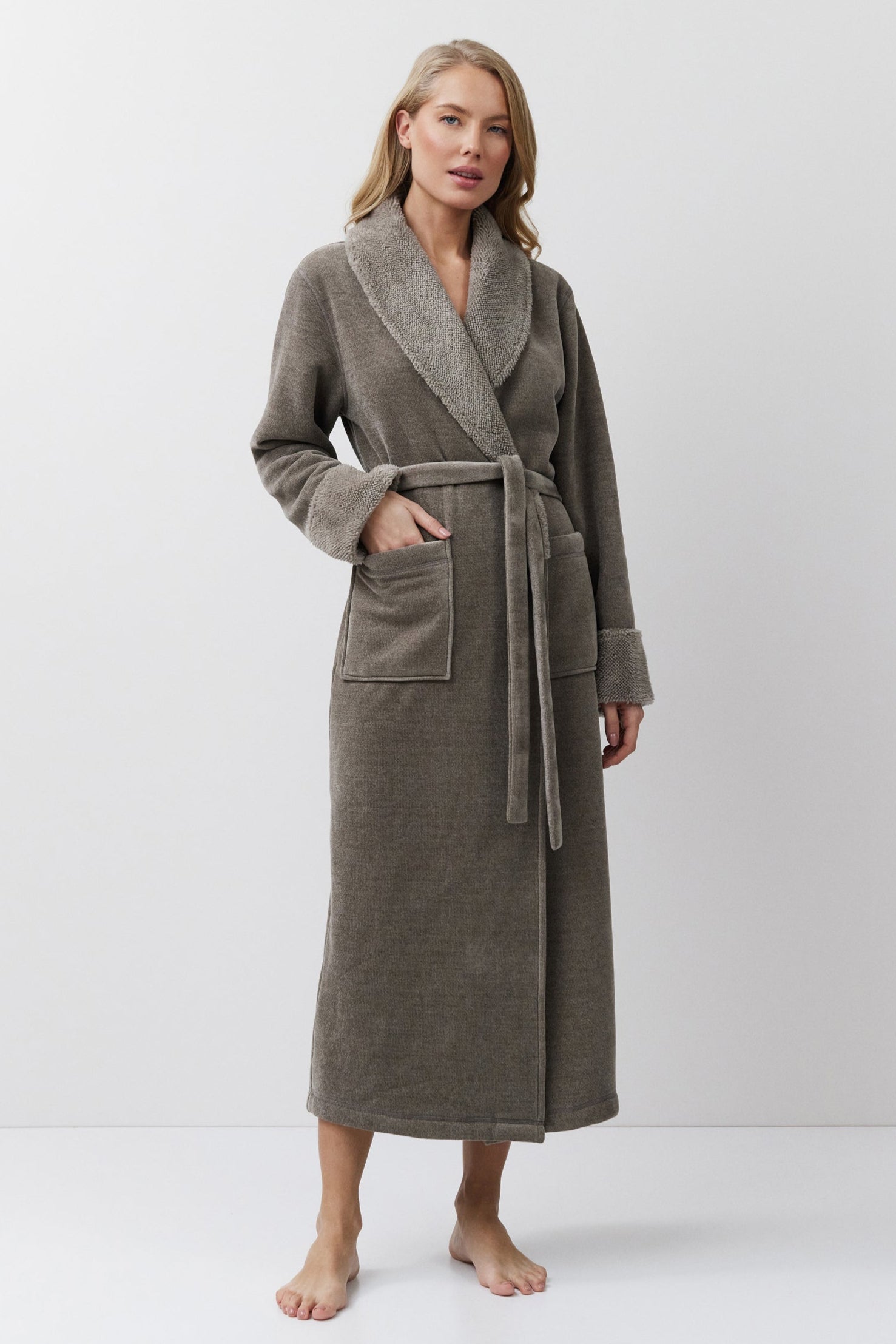 Woman wearing a long brown bathrobe on a white background
