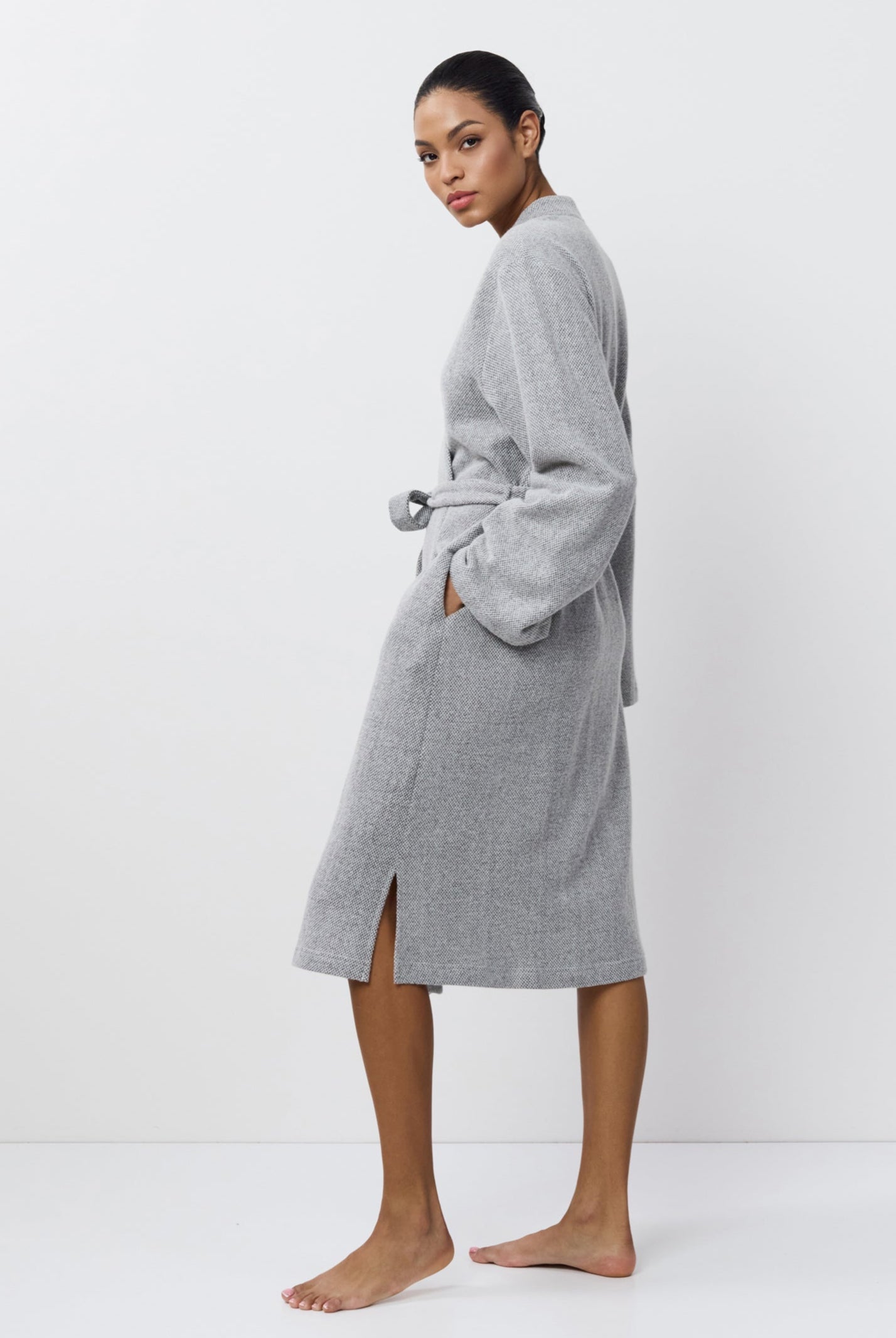 Person wearing a gray
bathrobe on a white background