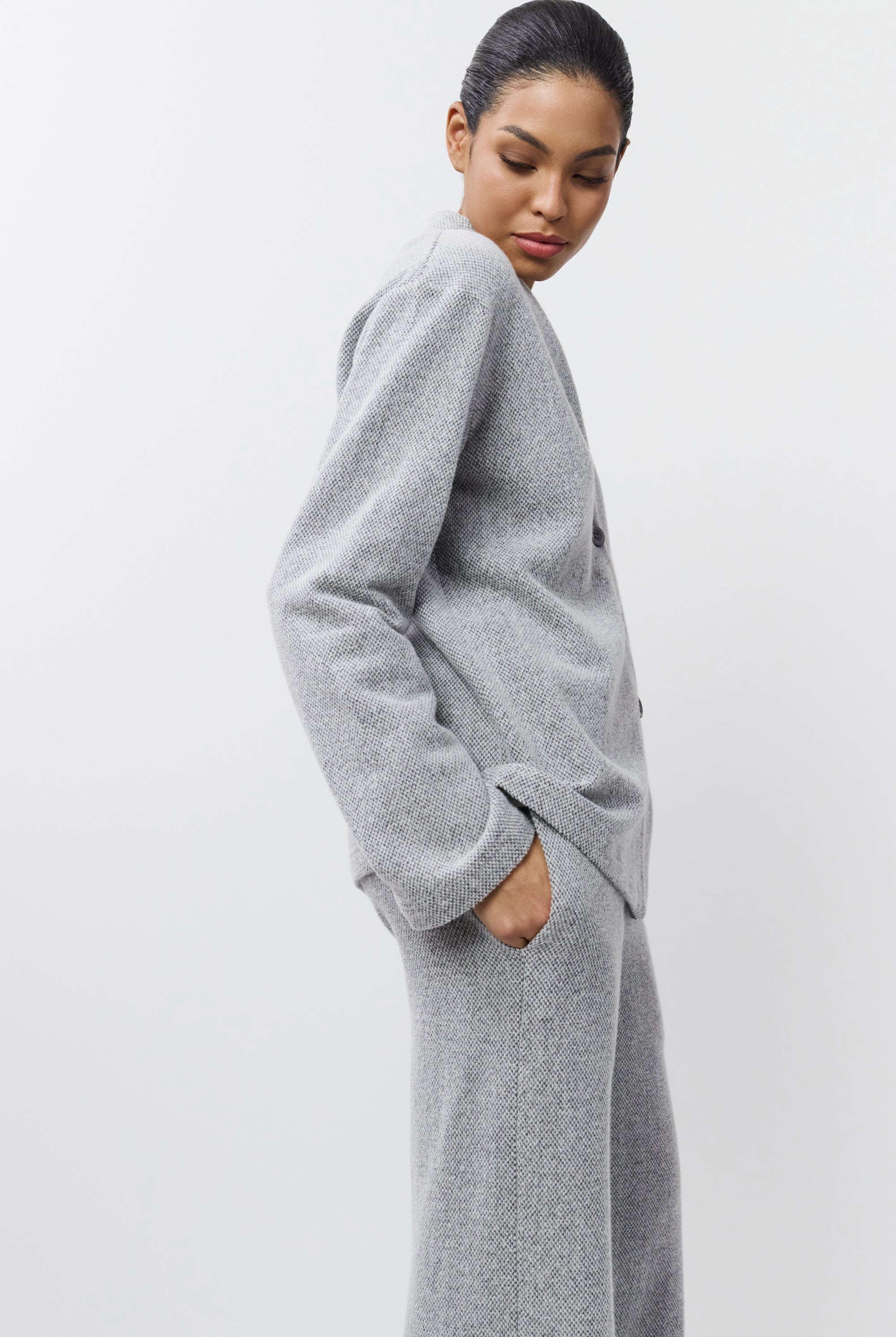 Woman wearing a gray set against a white background