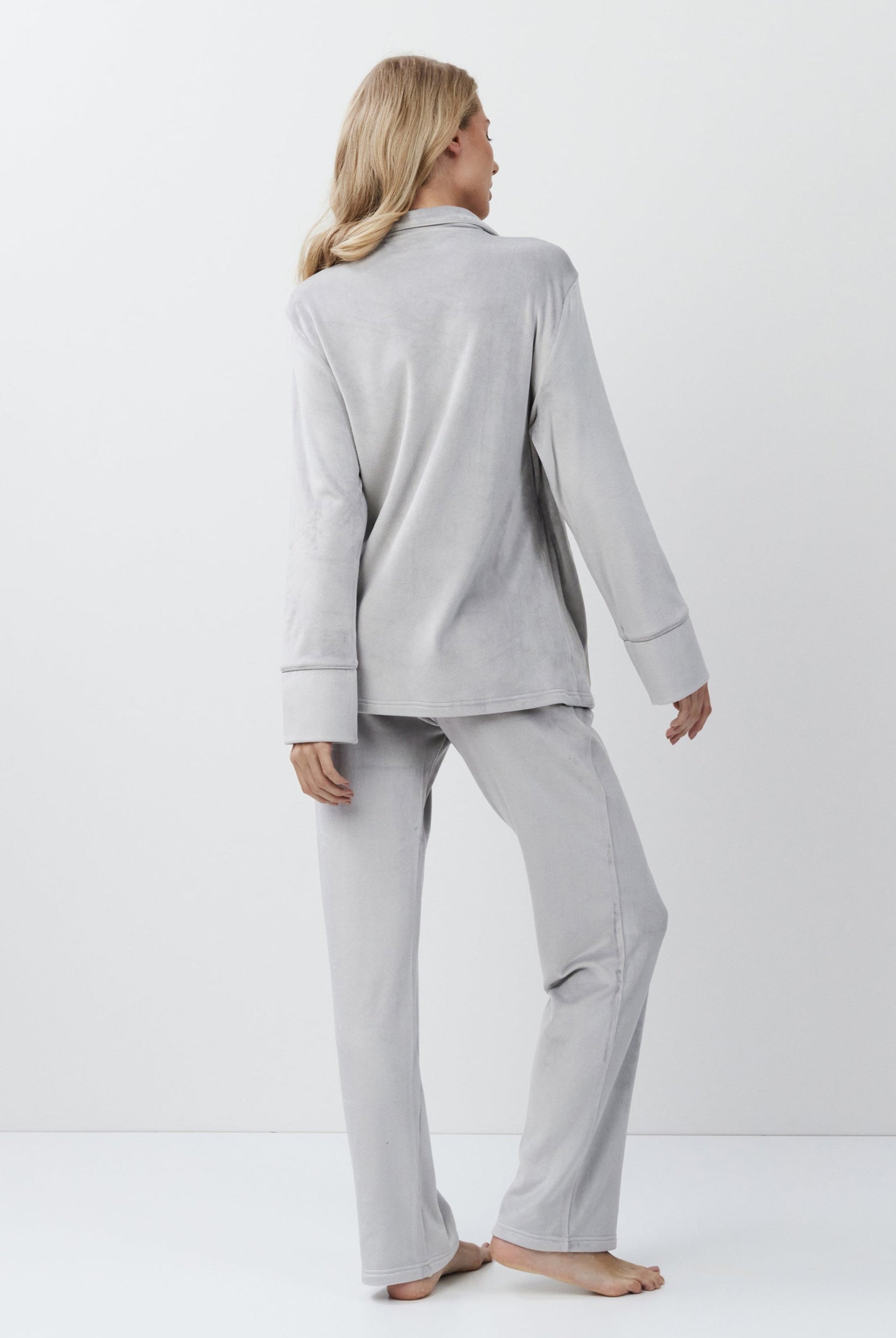 Woman wearing a gray set against a white background