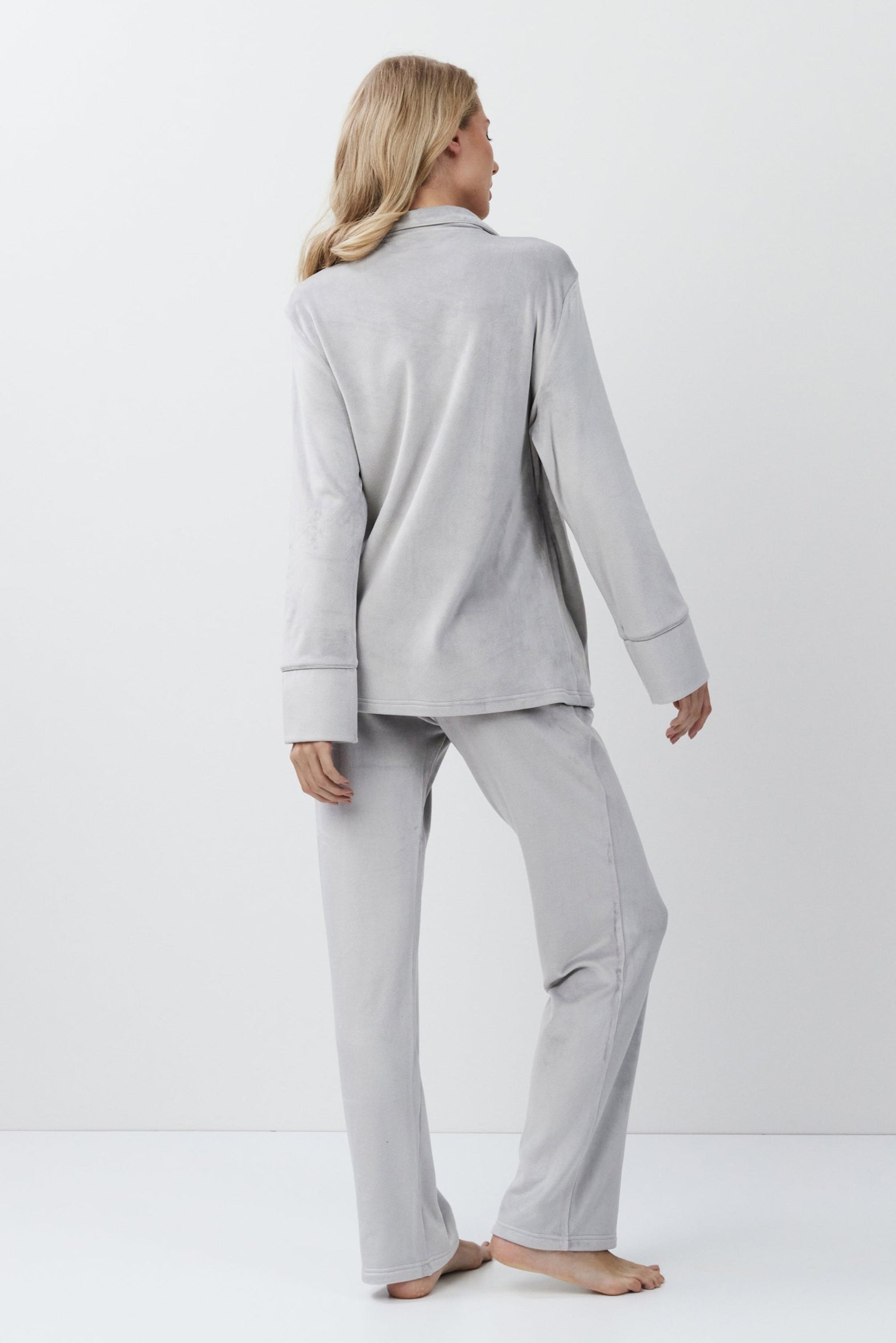 Woman wearing a gray set against a white background