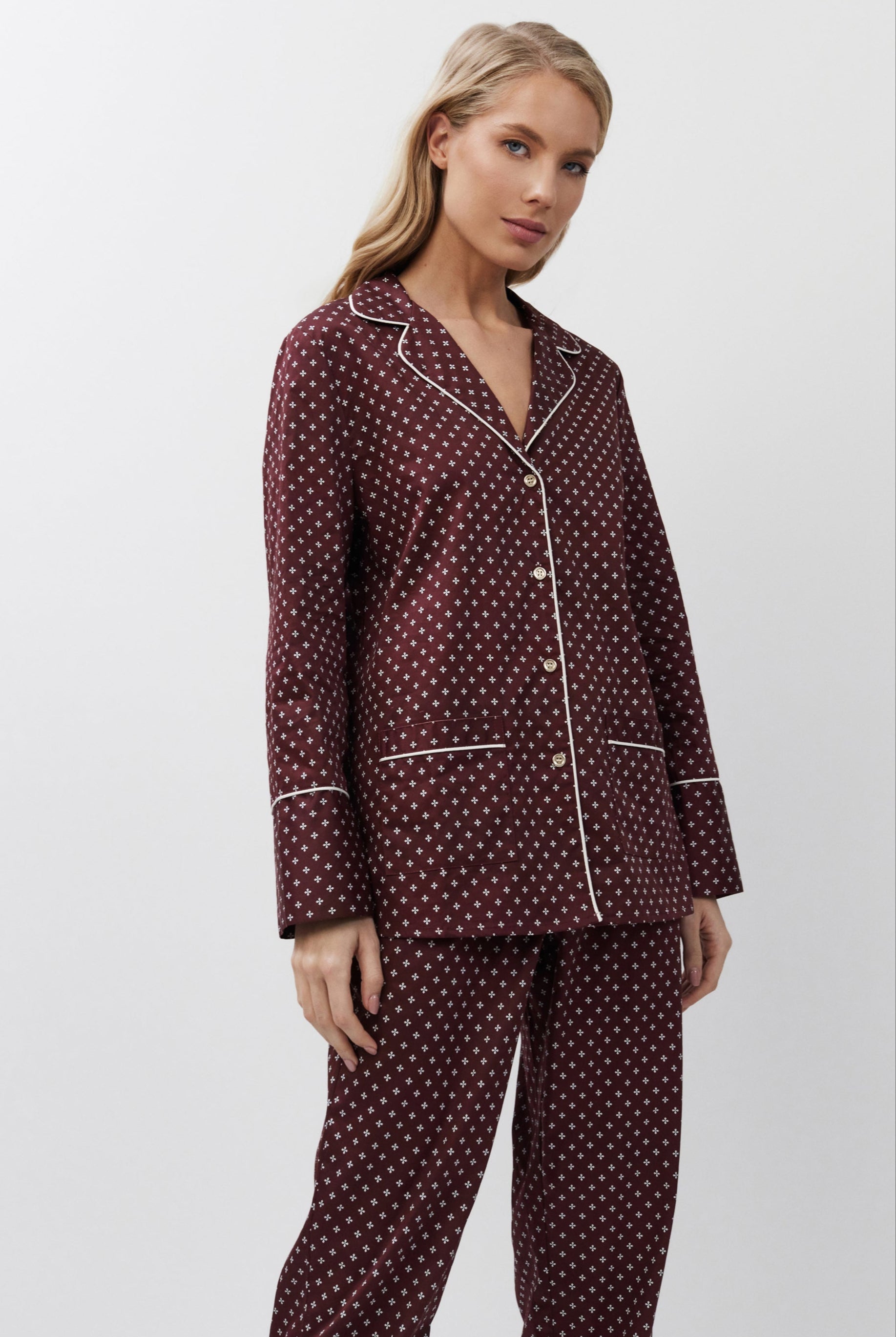 Woman wearing a burgundy pajama set on a white background