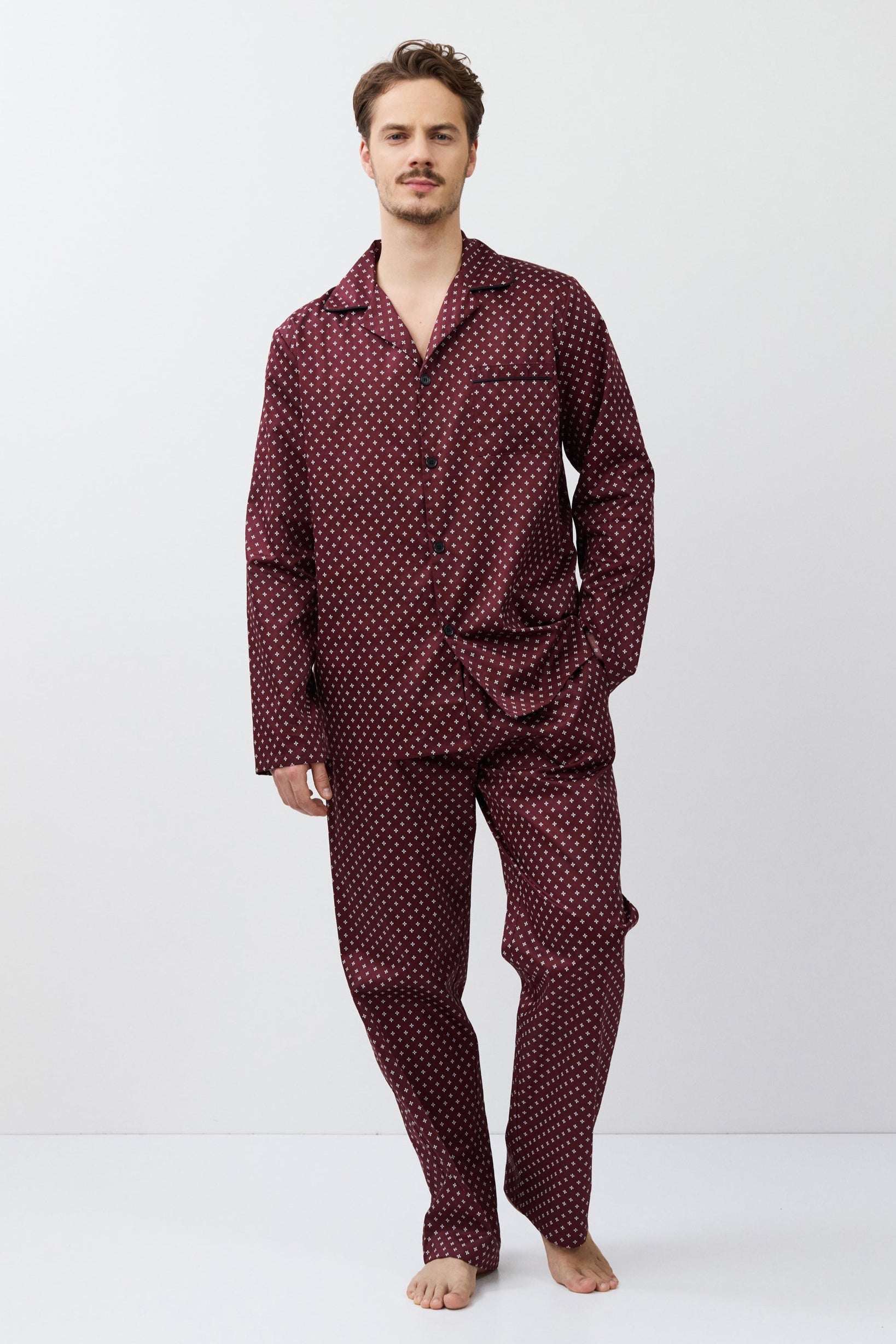 Man wearing a burgundy pajama set on a white background