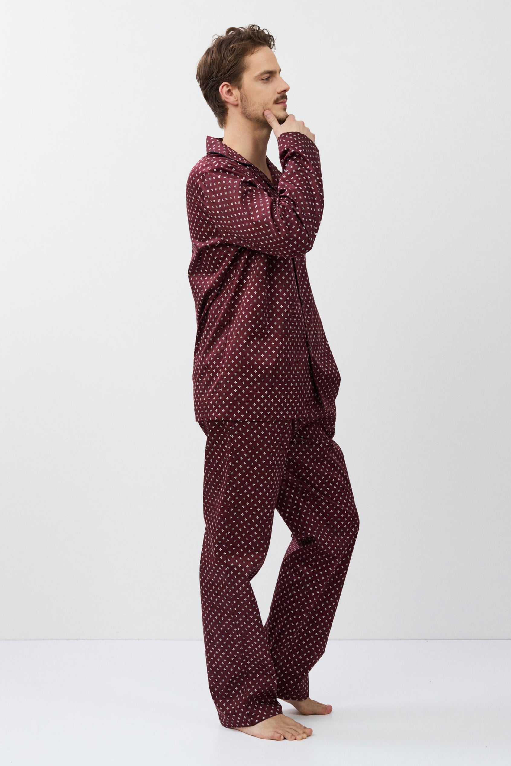 Man wearing a burgundy pajama set on a white background