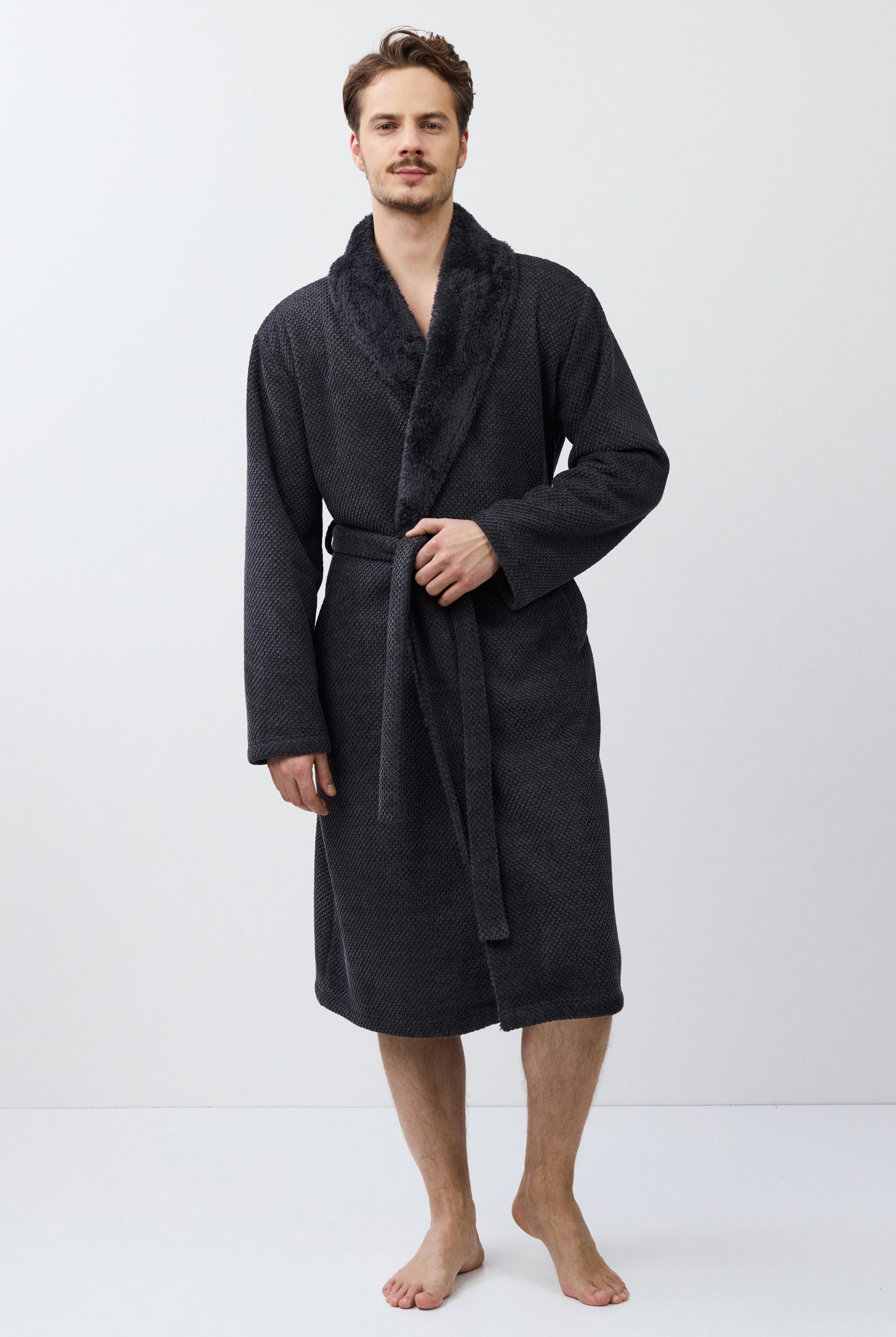 Man wearing a dark gray bathrobe on a white background