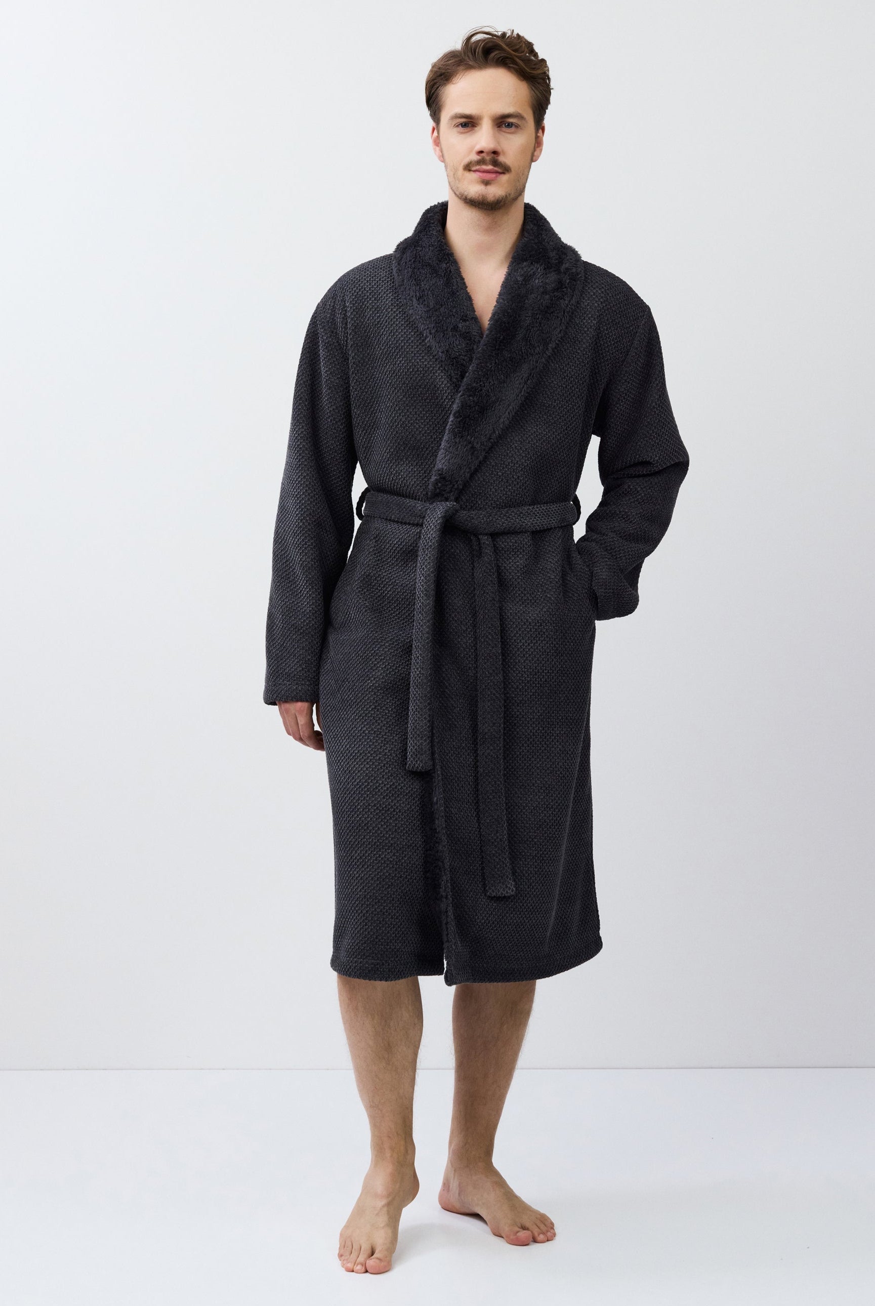Man wearing a dark gray bathrobe on a white background