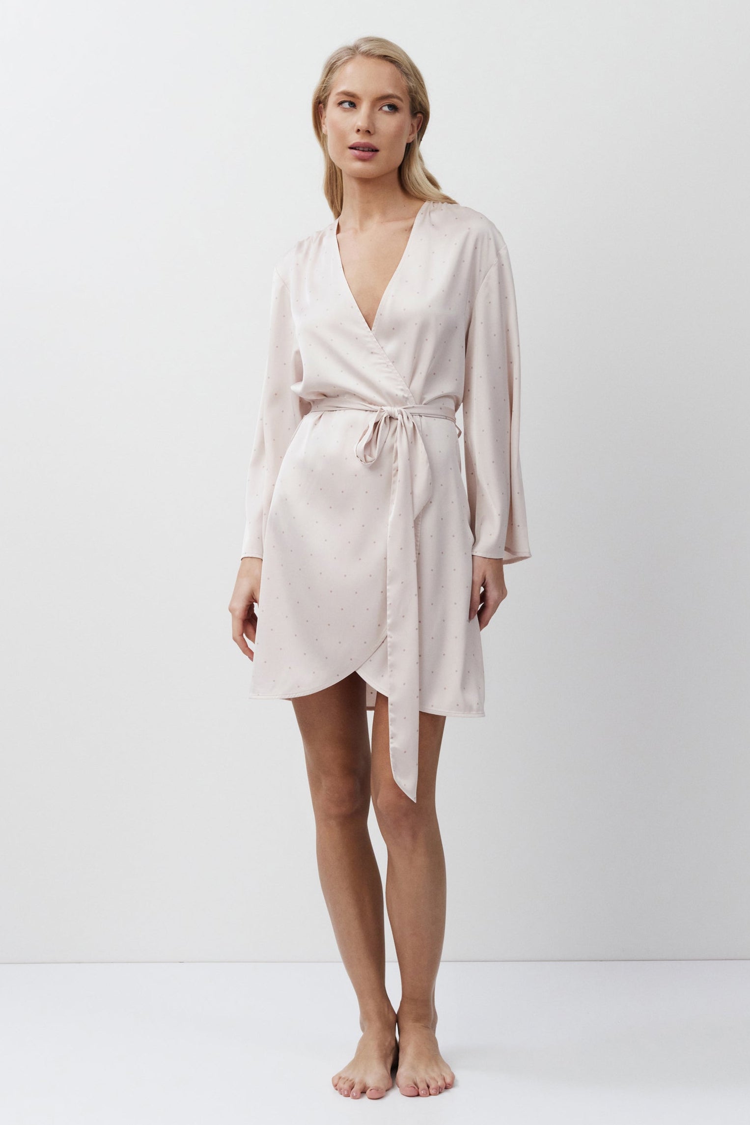 Woman wearing a light pink gown against a white background