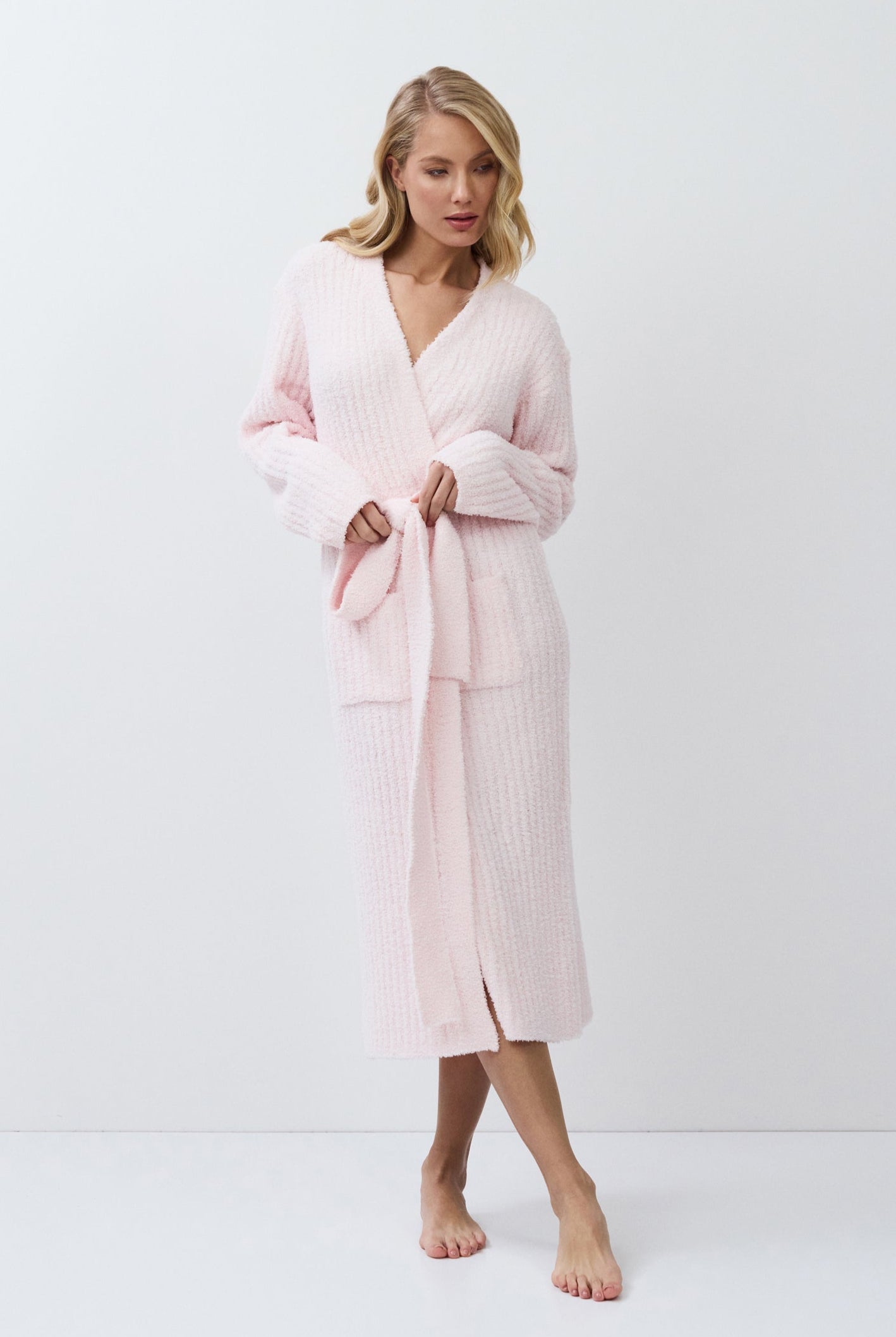 Woman wearing a pink bathrobe against a white background