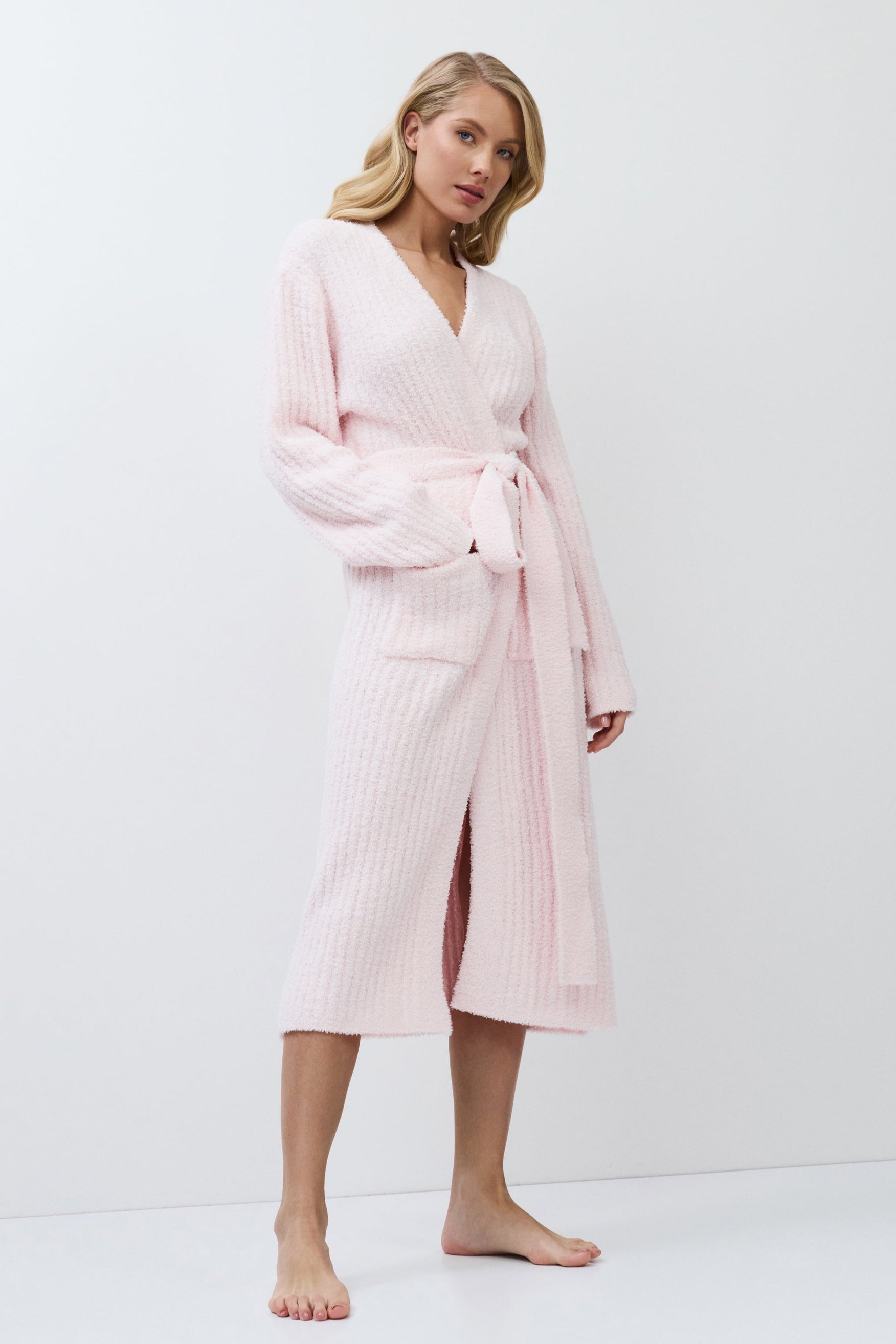 Woman wearing a pink bathrobe against a white background