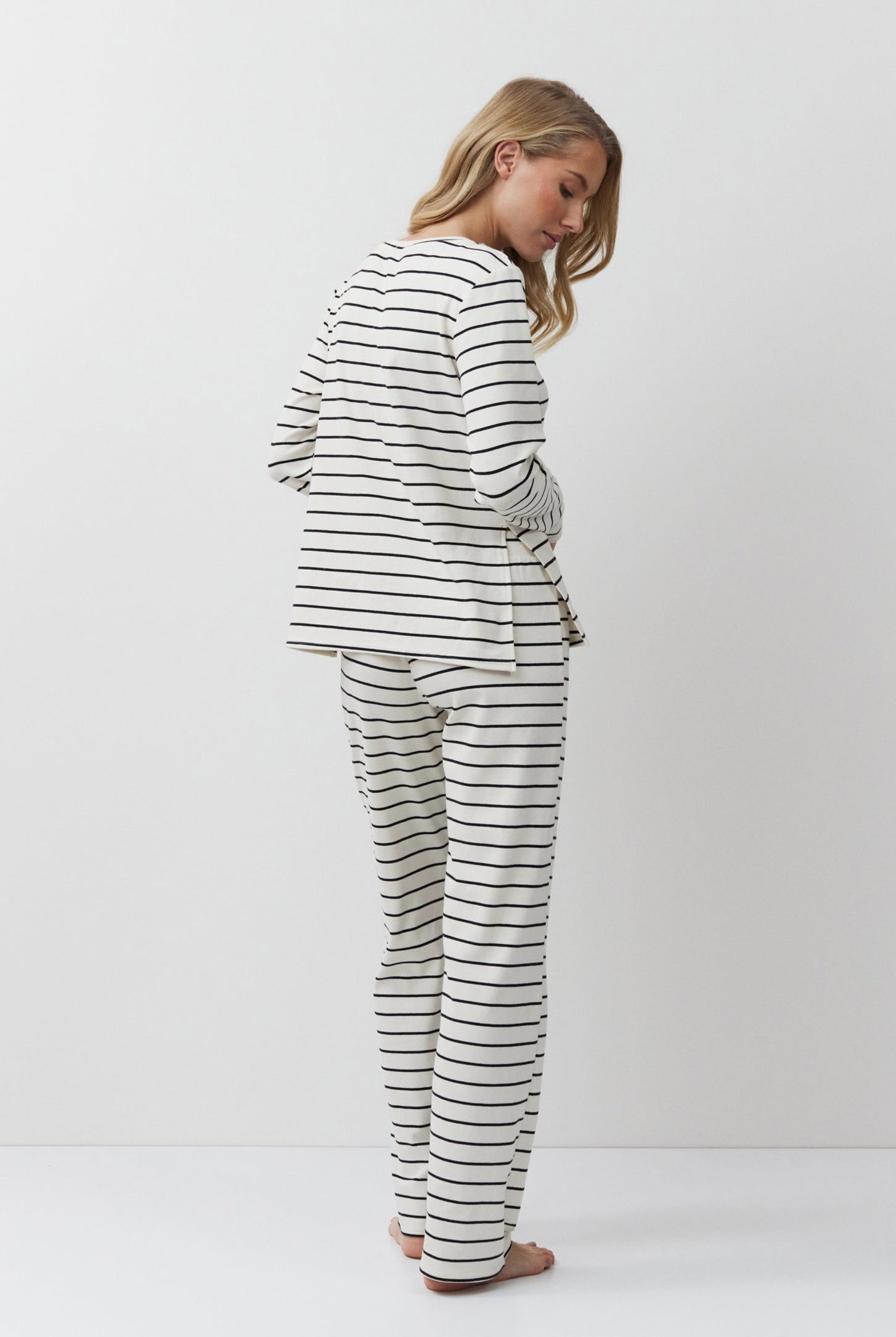 Person wearing a striped pajama set on a white background