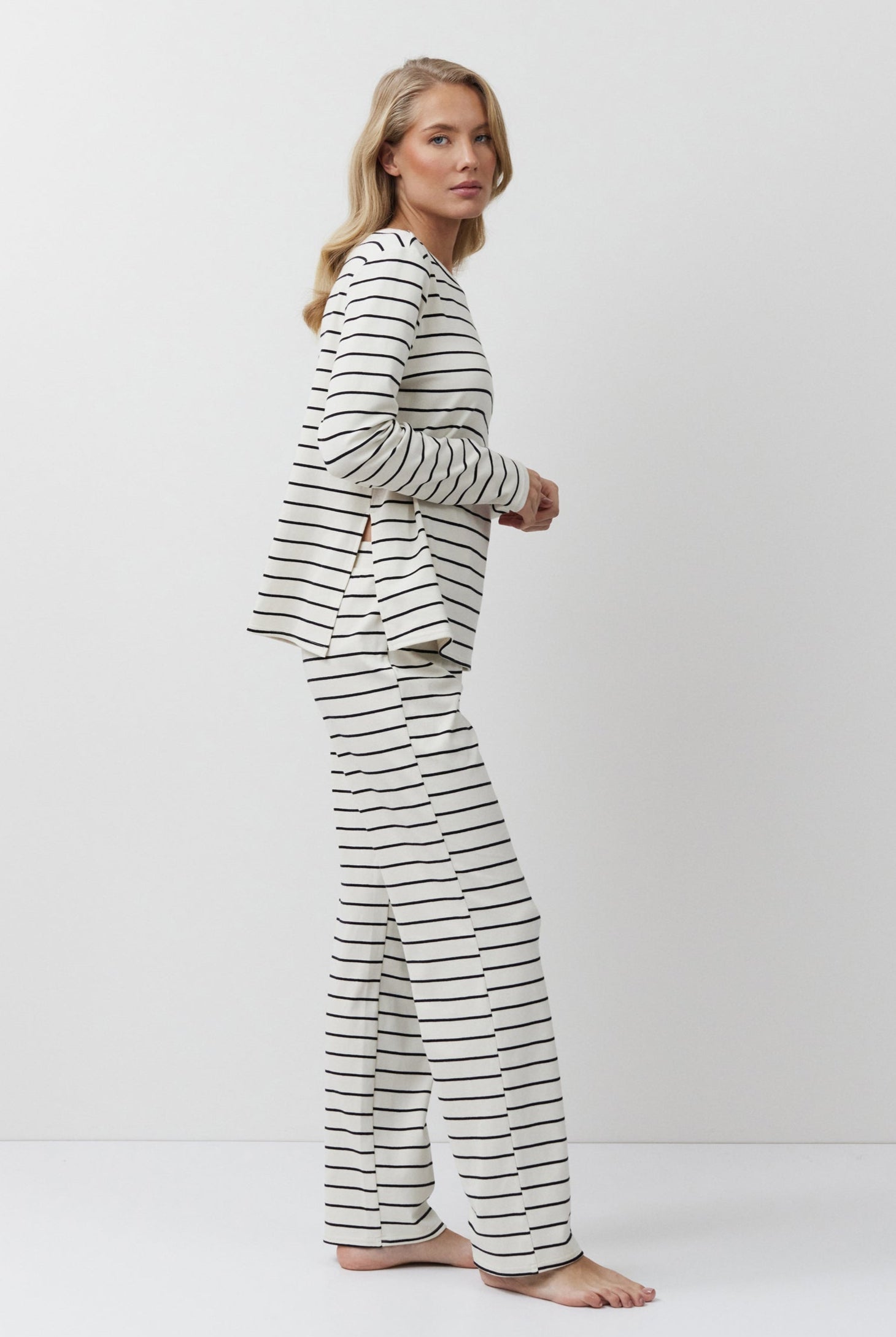 Woman wearing a striped pajama set on a white background