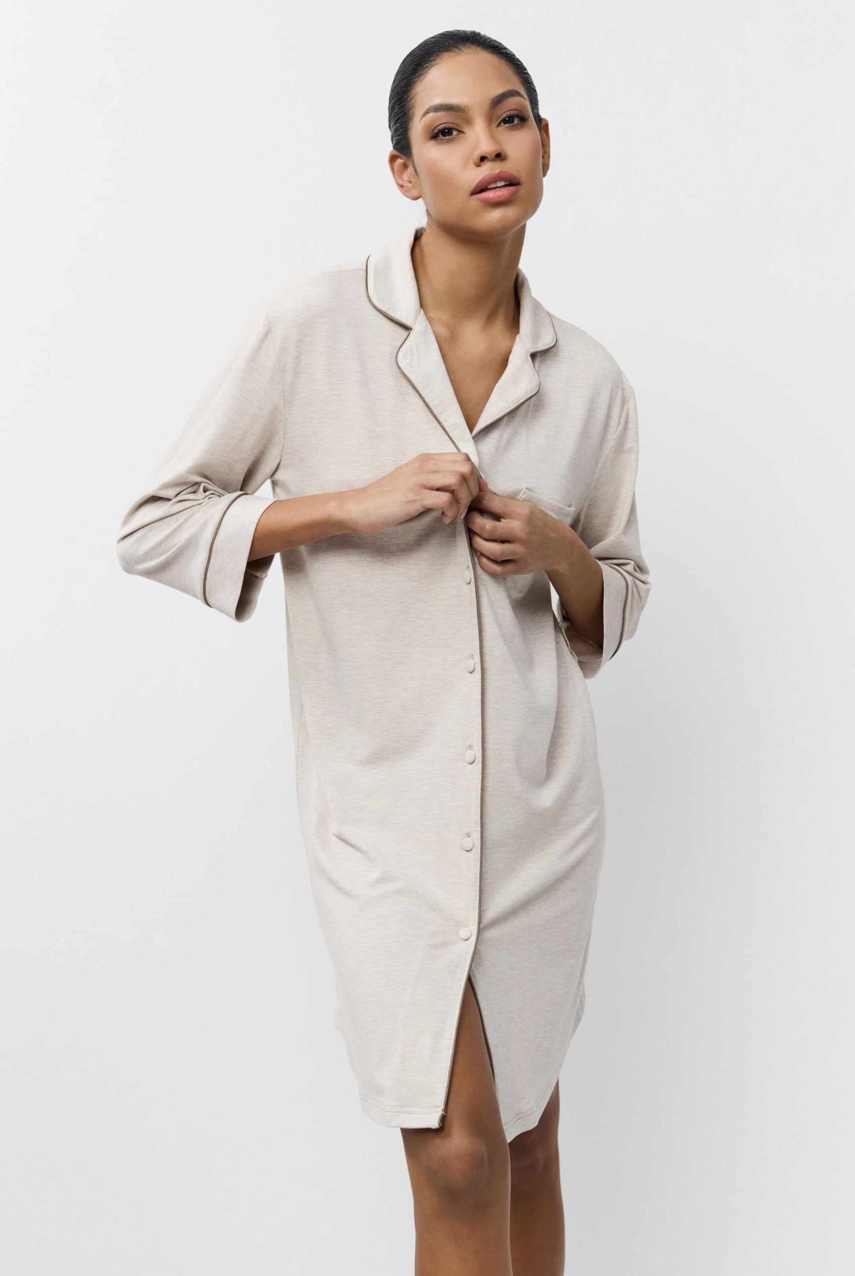 Woman wearing a beige nightdress against a white background