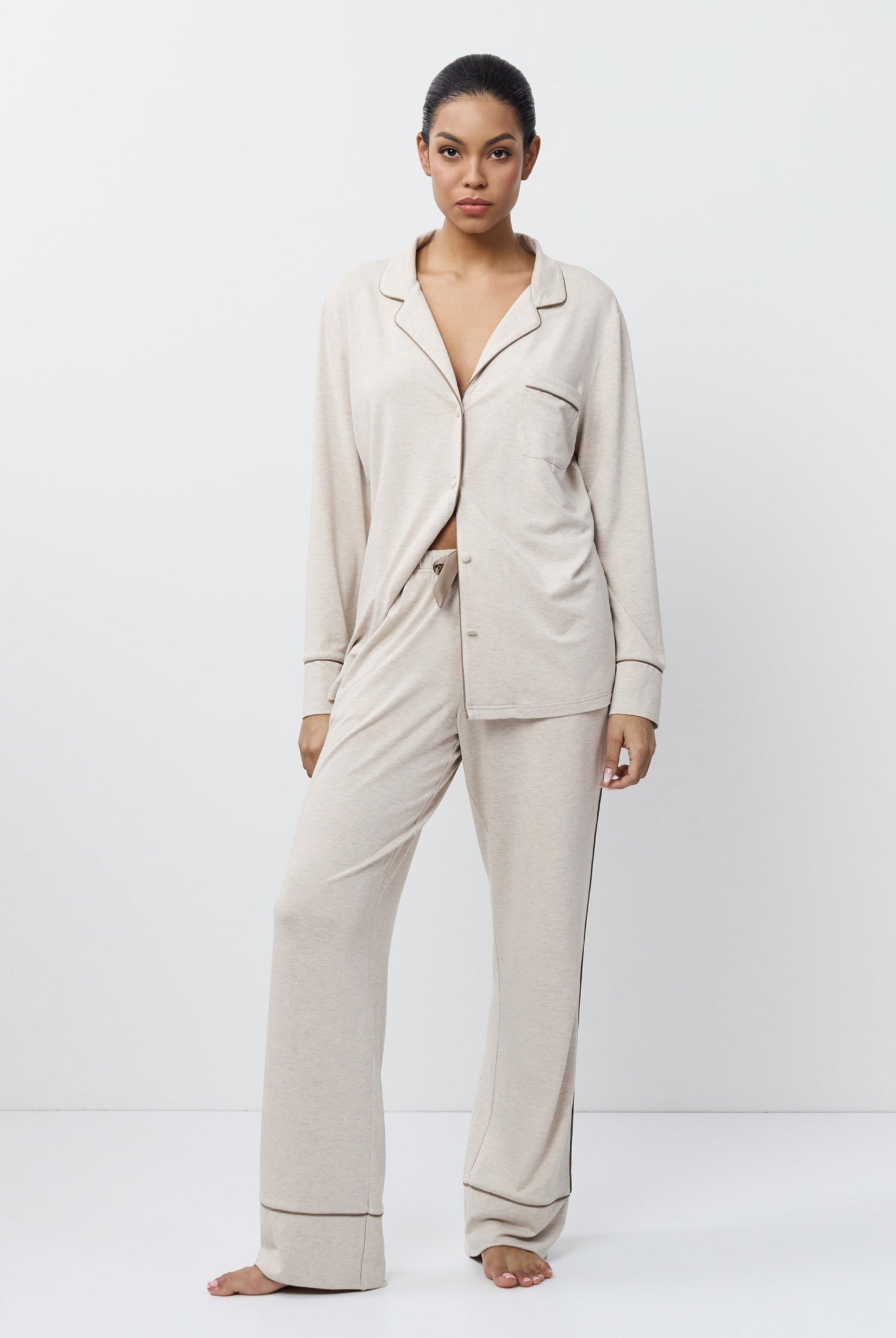 Woman wearing a beige pajama set on a white background