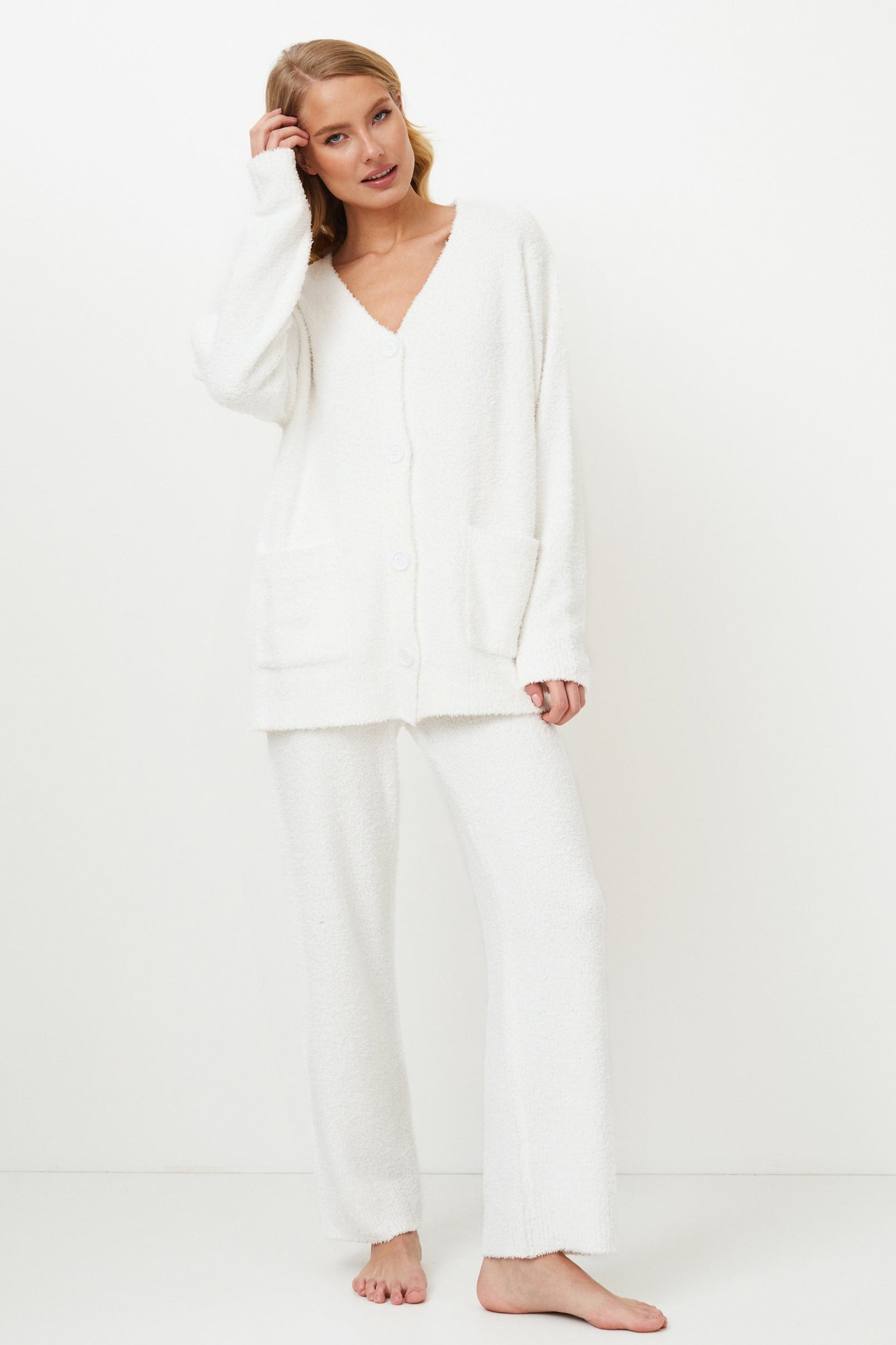 Woman wearing a white homewear set against a white background