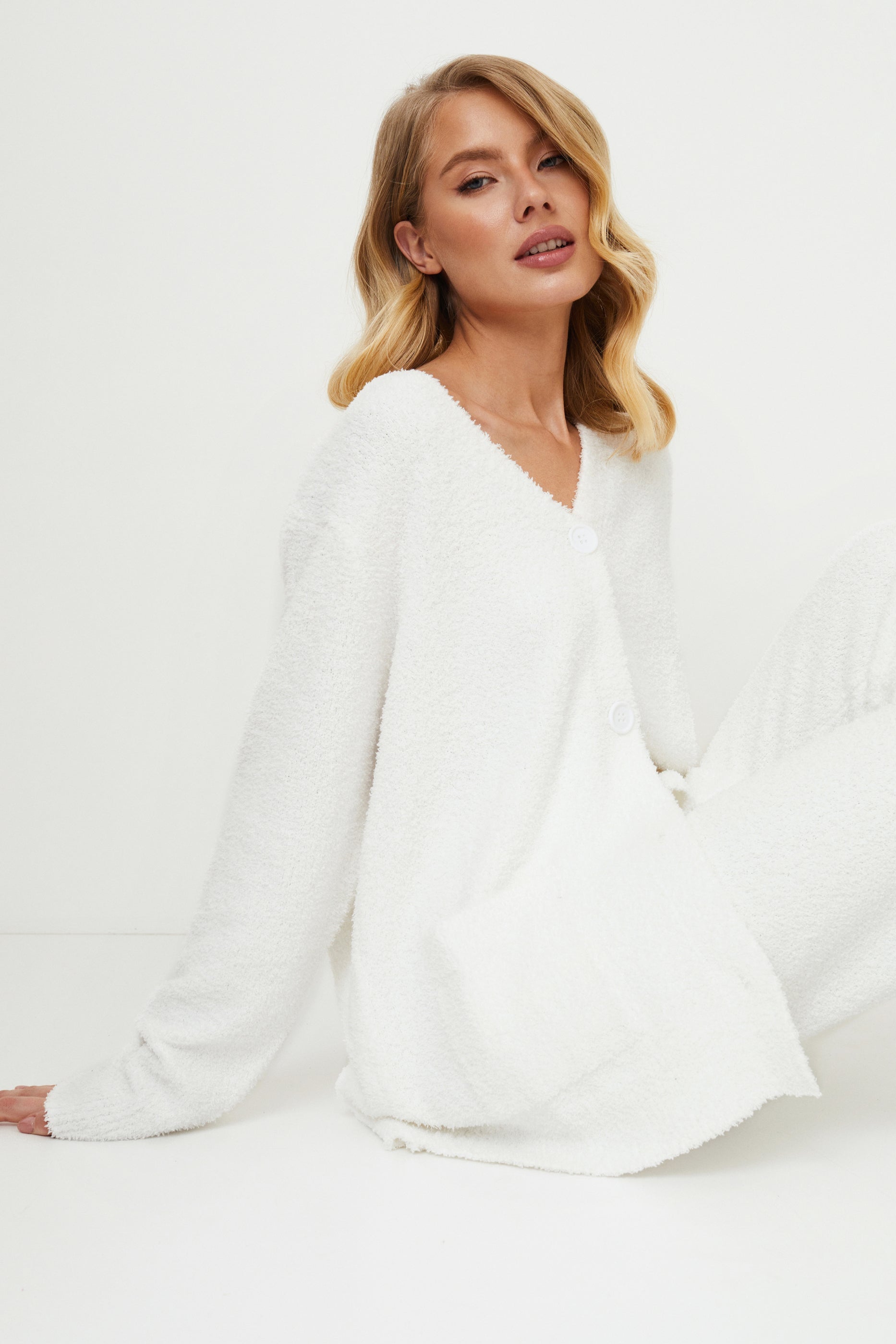 Woman wearing a white homewear set against white background