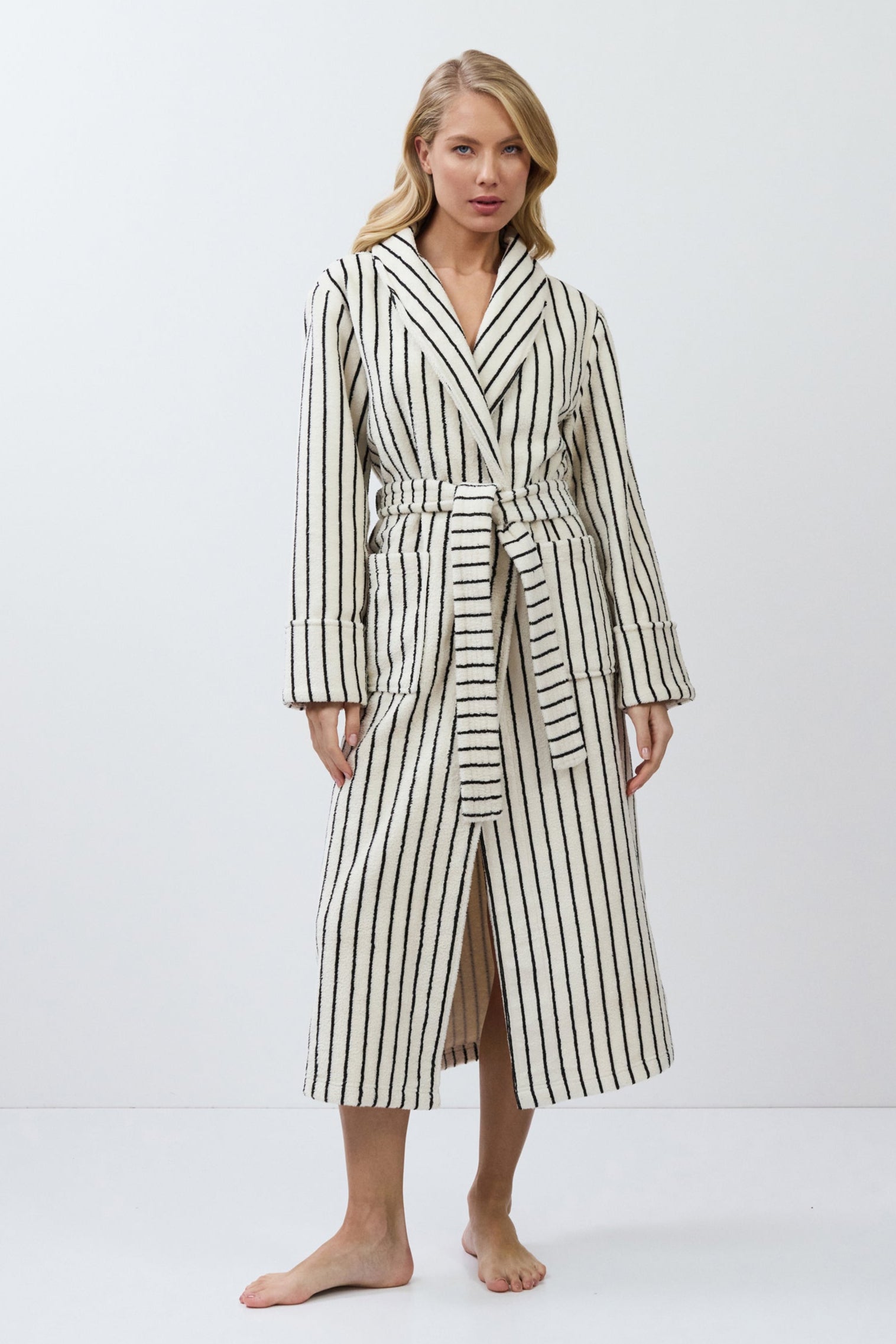 Woman wearing a striped bathrobe on a white background